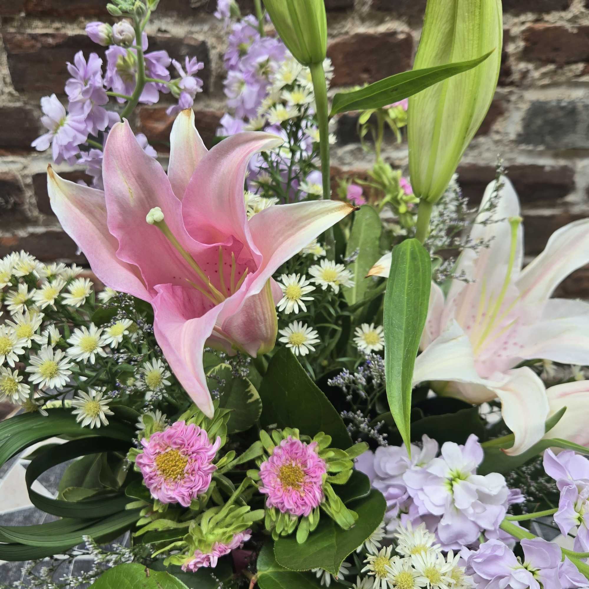 Bouquet of pink and white lilies with small purple and white filler flowers