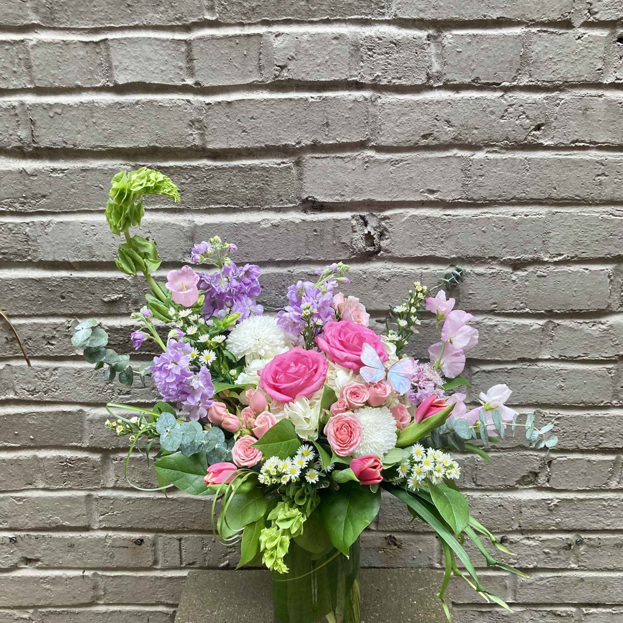 Pink and purple mixed flower arrangement in a glass vase
