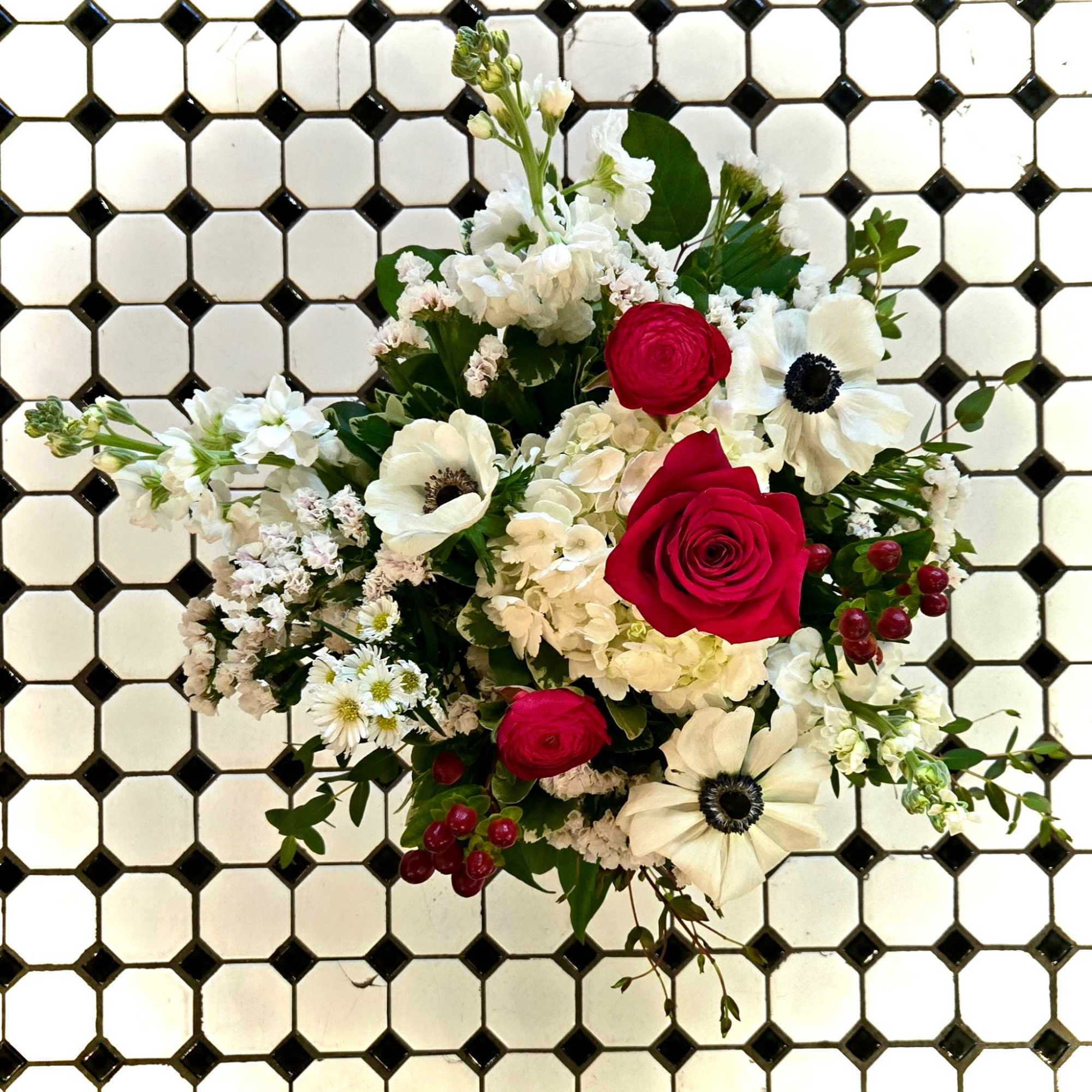 The Summer Picnic pairs vivid red roses and ranunculus with crisp white