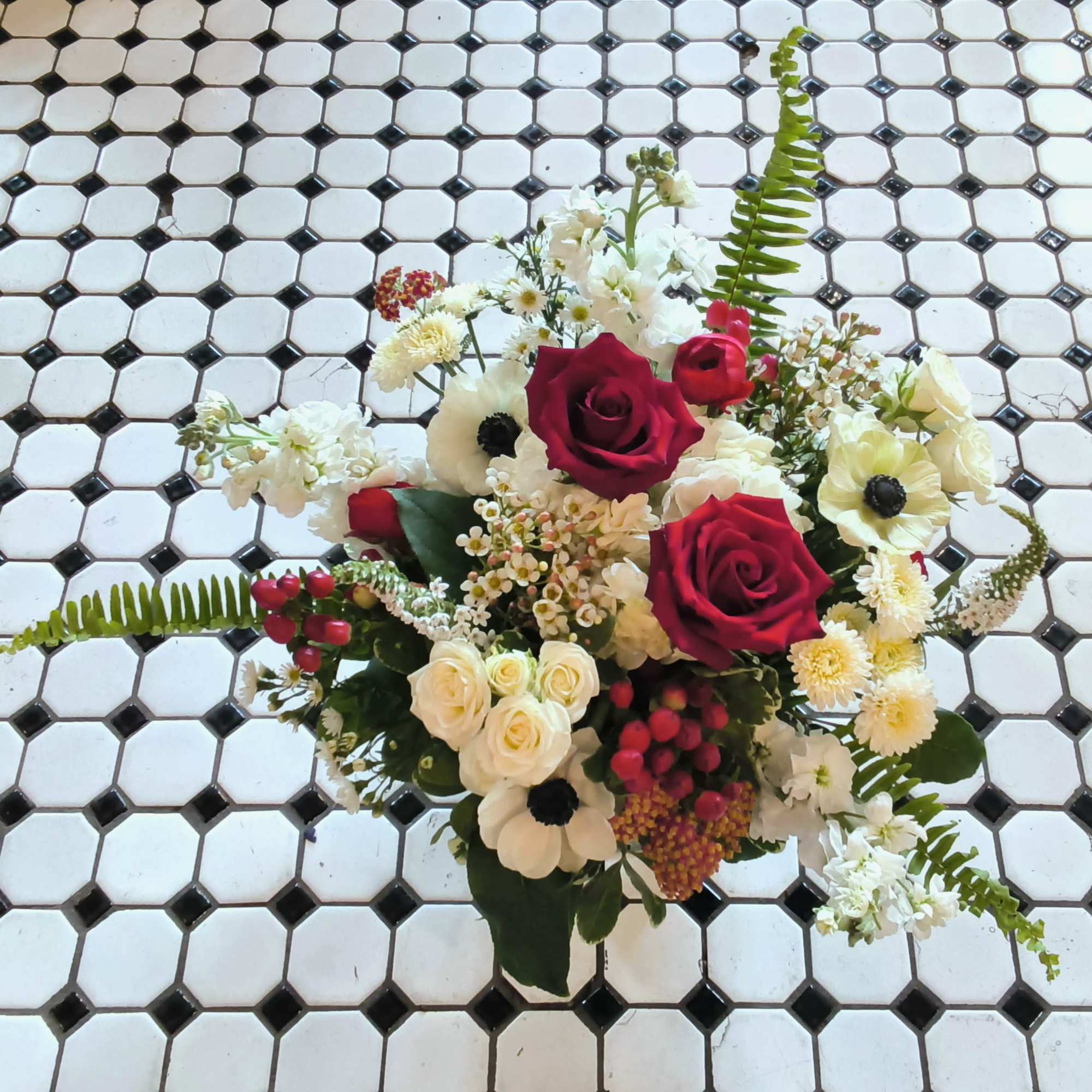 The Summer Picnic pairs vivid red roses and ranunculus with crisp white