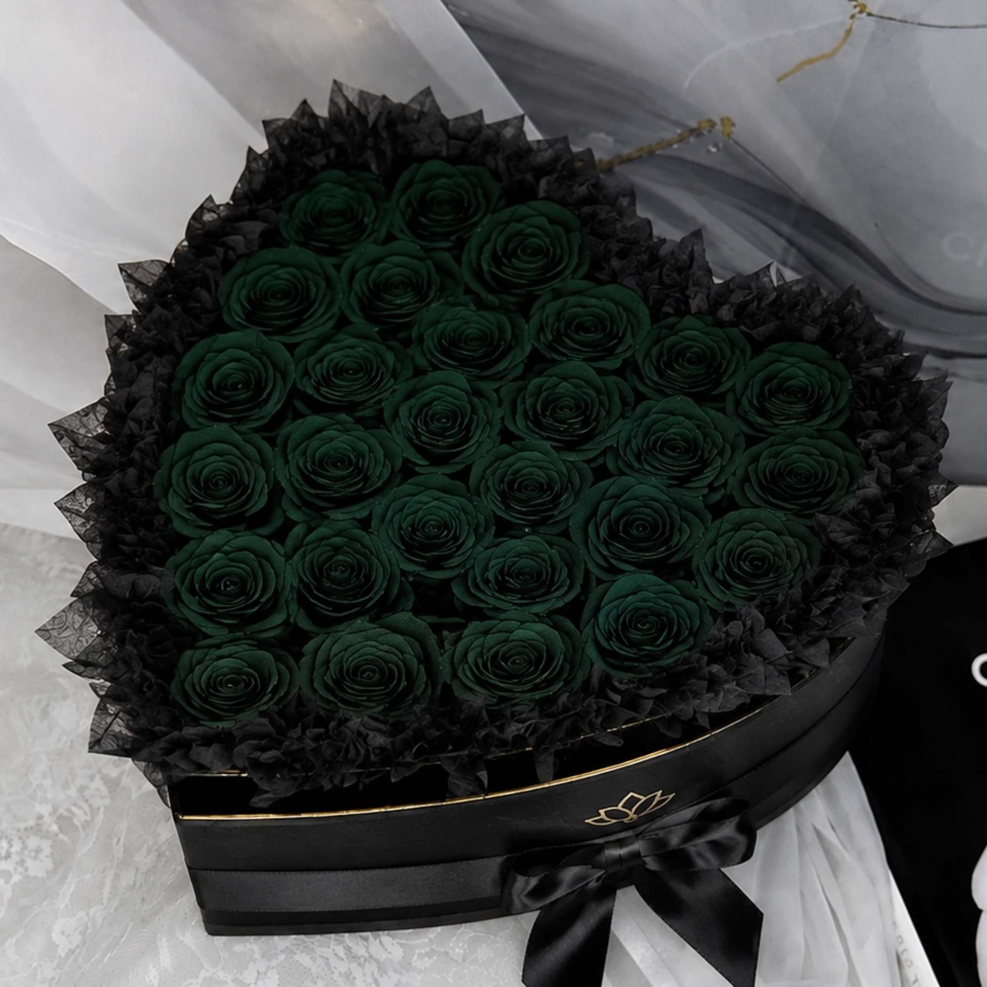 Round bouquet of dark green roses in a black box with a ribbon
