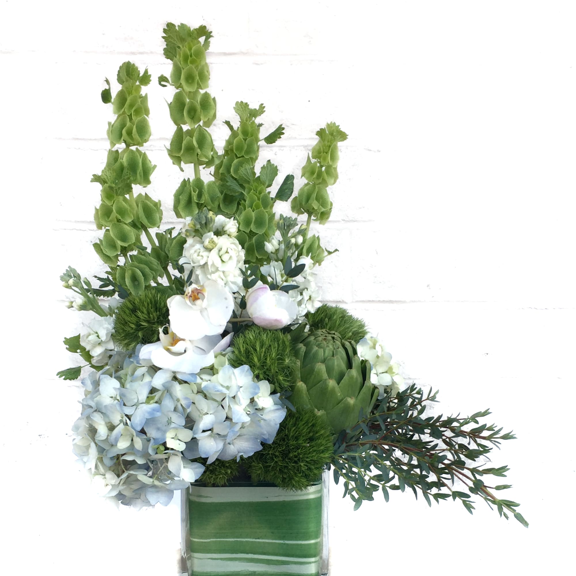 Fresh design including Bells of Ireland, hydrangea, lily, rose... and accents. 
STANDARD:, photo 2 of 3