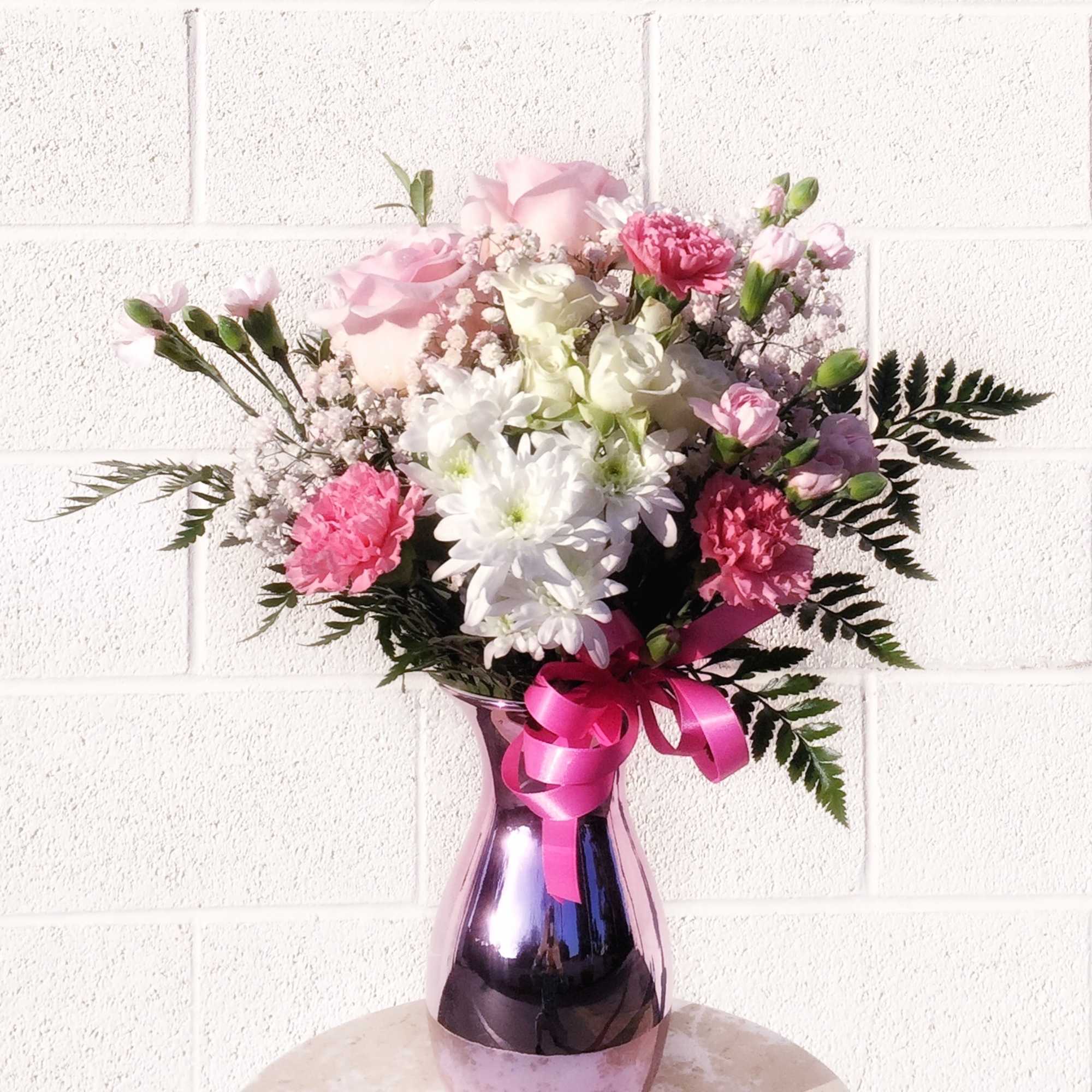 Pretty design including white and pastel pink fresh flowers and accents in