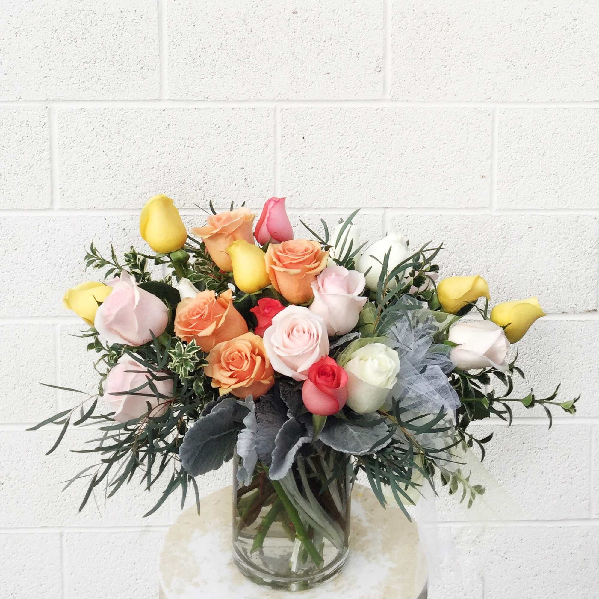 Bouquet of multicolored roses in a clear glass vase