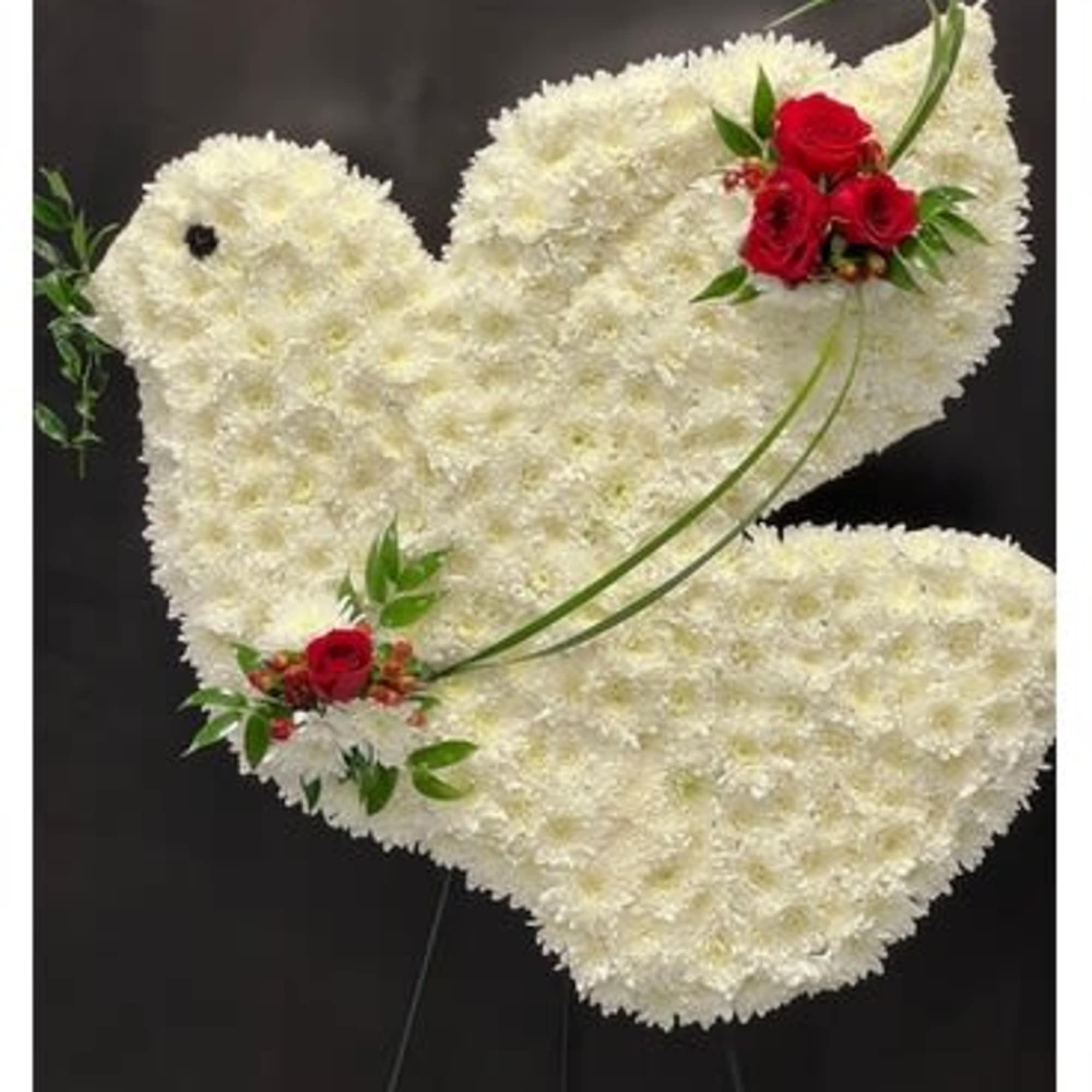 White floral dove-shaped standing spray with red rose accents