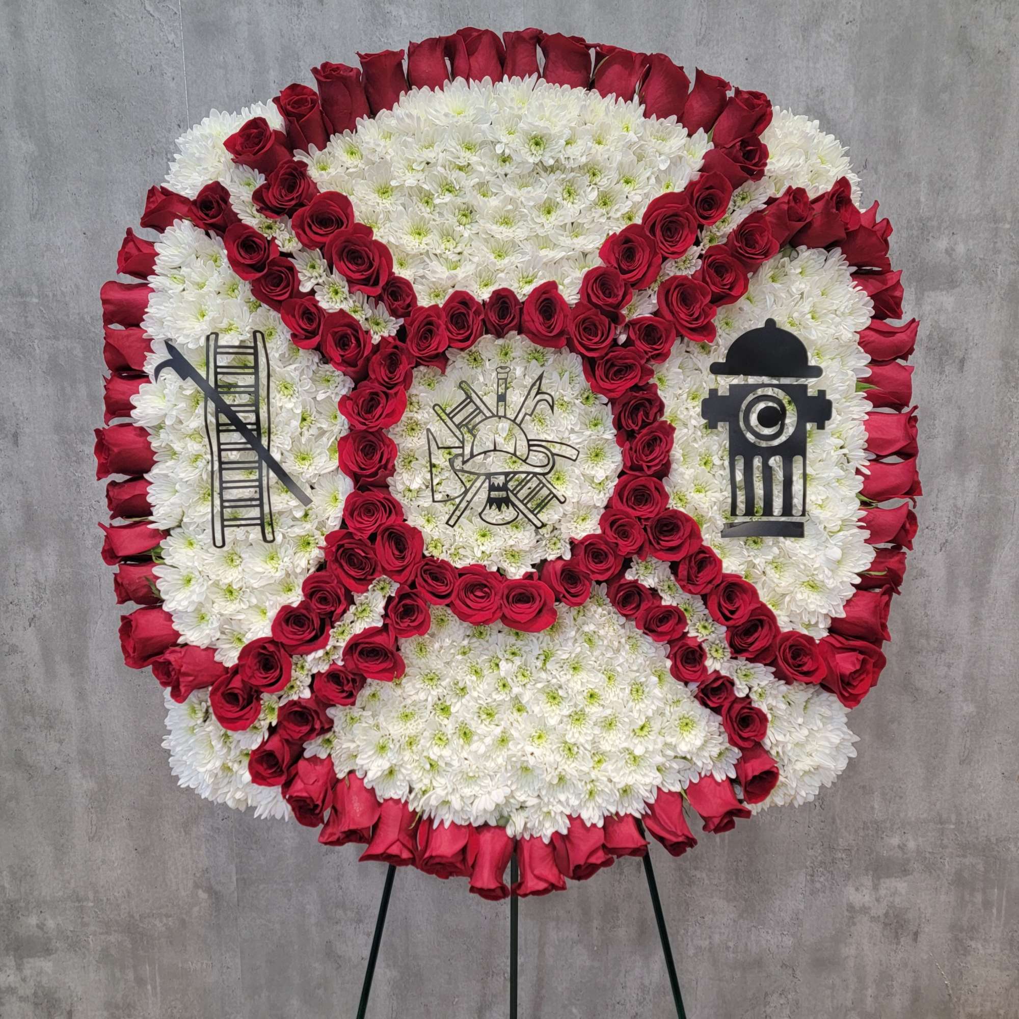 Circular floral wreath of red roses and white chrysanthemums on an easel