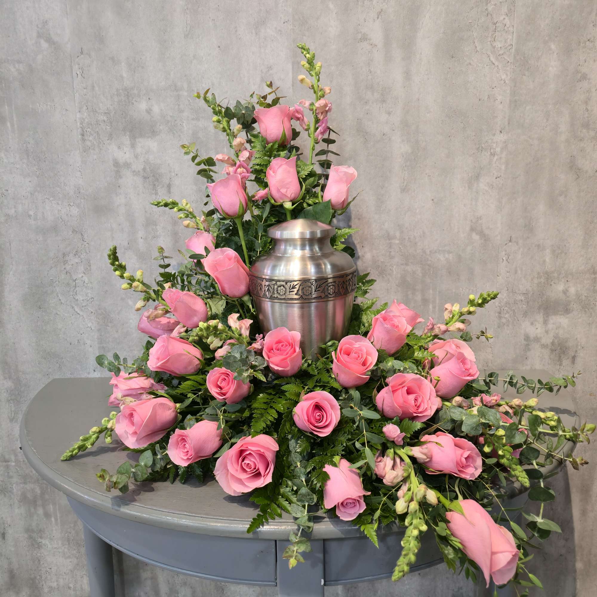 This stunning urn spray of two dozen white roses is a beautiful