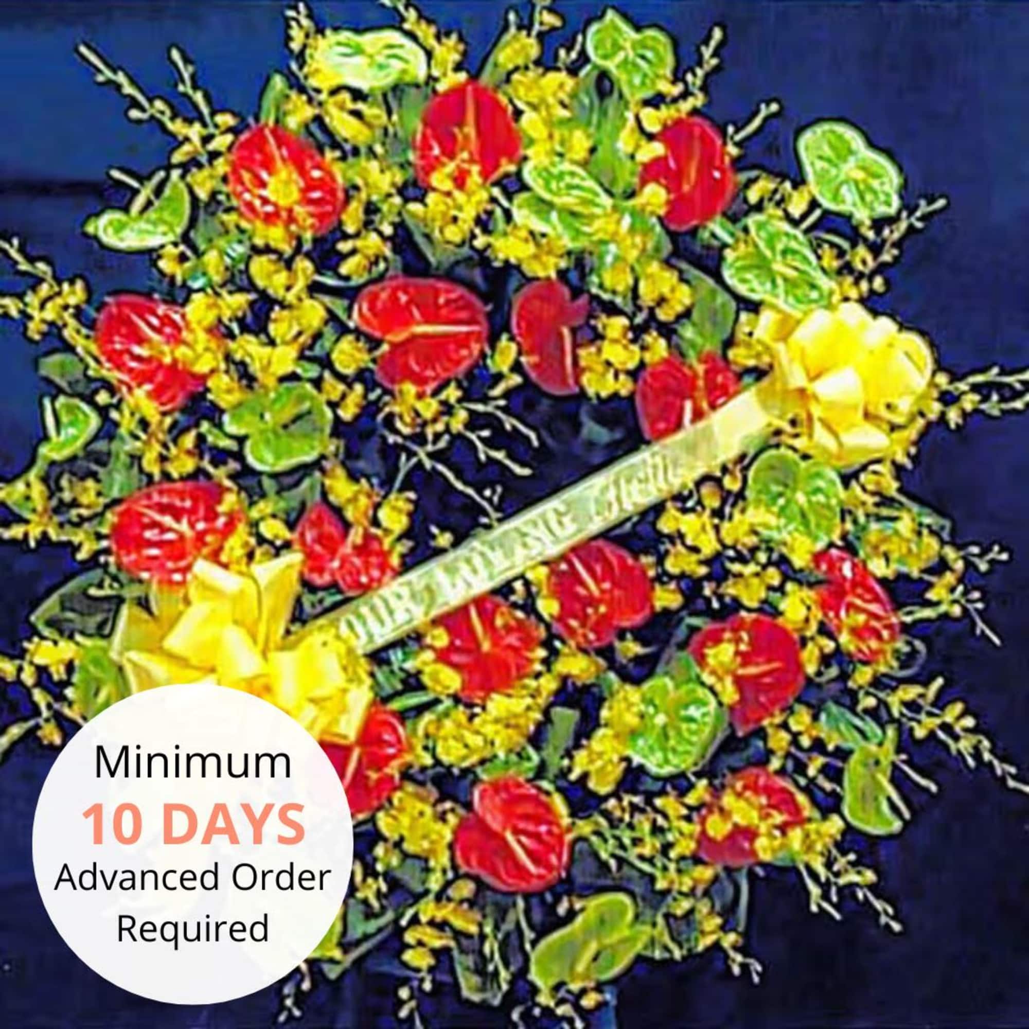 Round sympathy wreath with red and green tropical blooms, yellow flowers, and a yellow memorial ribbon.