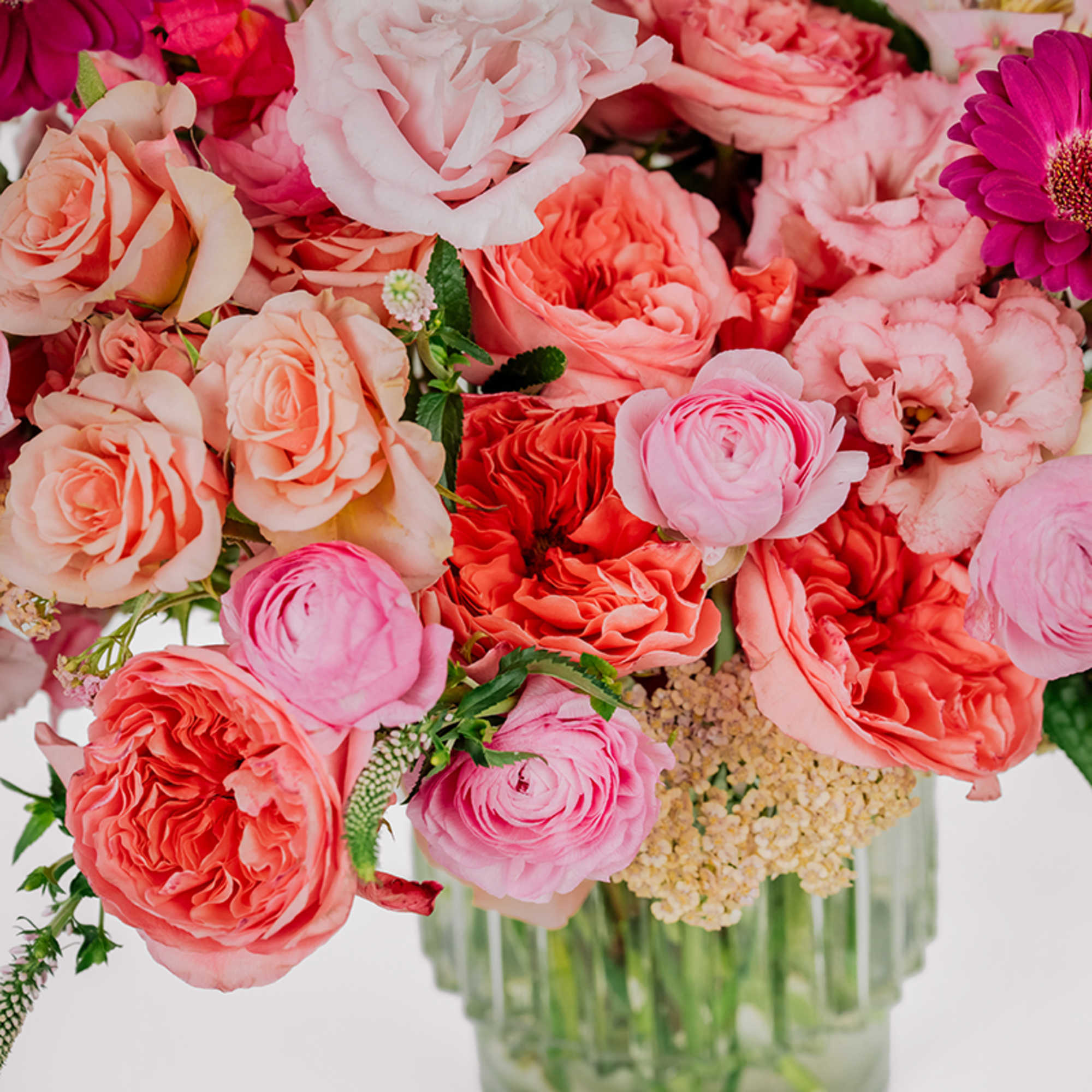 Mixed pink and coral roses in a clear glass vase
