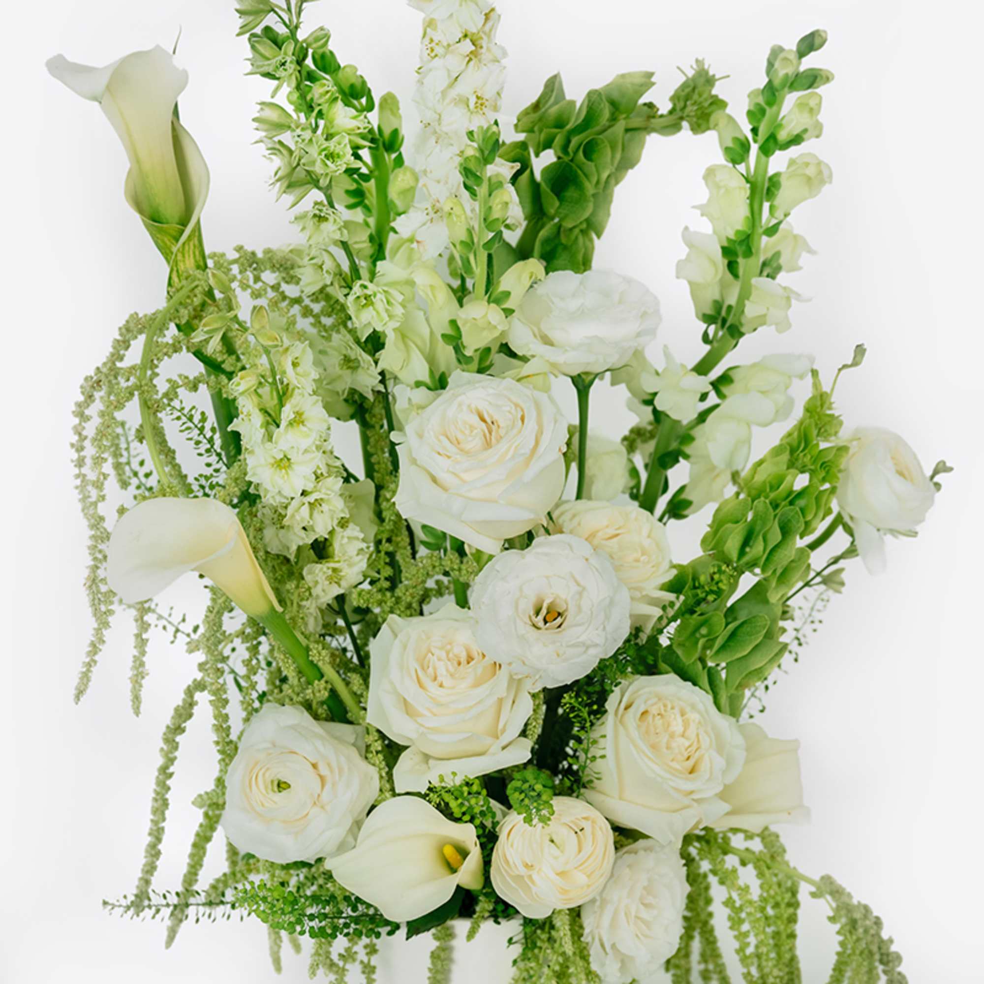 White floral arrangement with calla lilies, roses, and tall green-and-white spikes