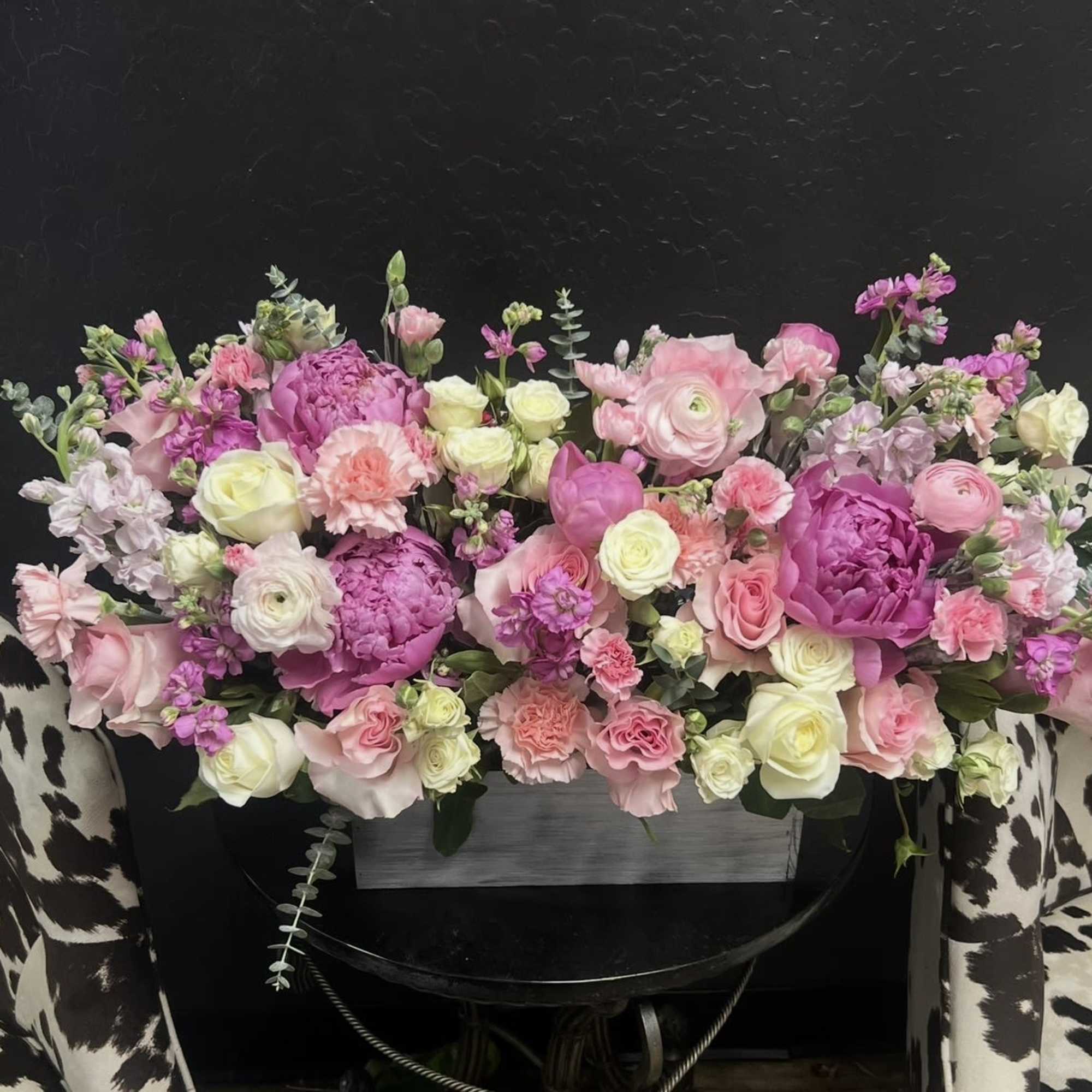 Lush pink peonies and soft ranunculus create a romantic, garden-fresh centerpiece perfect