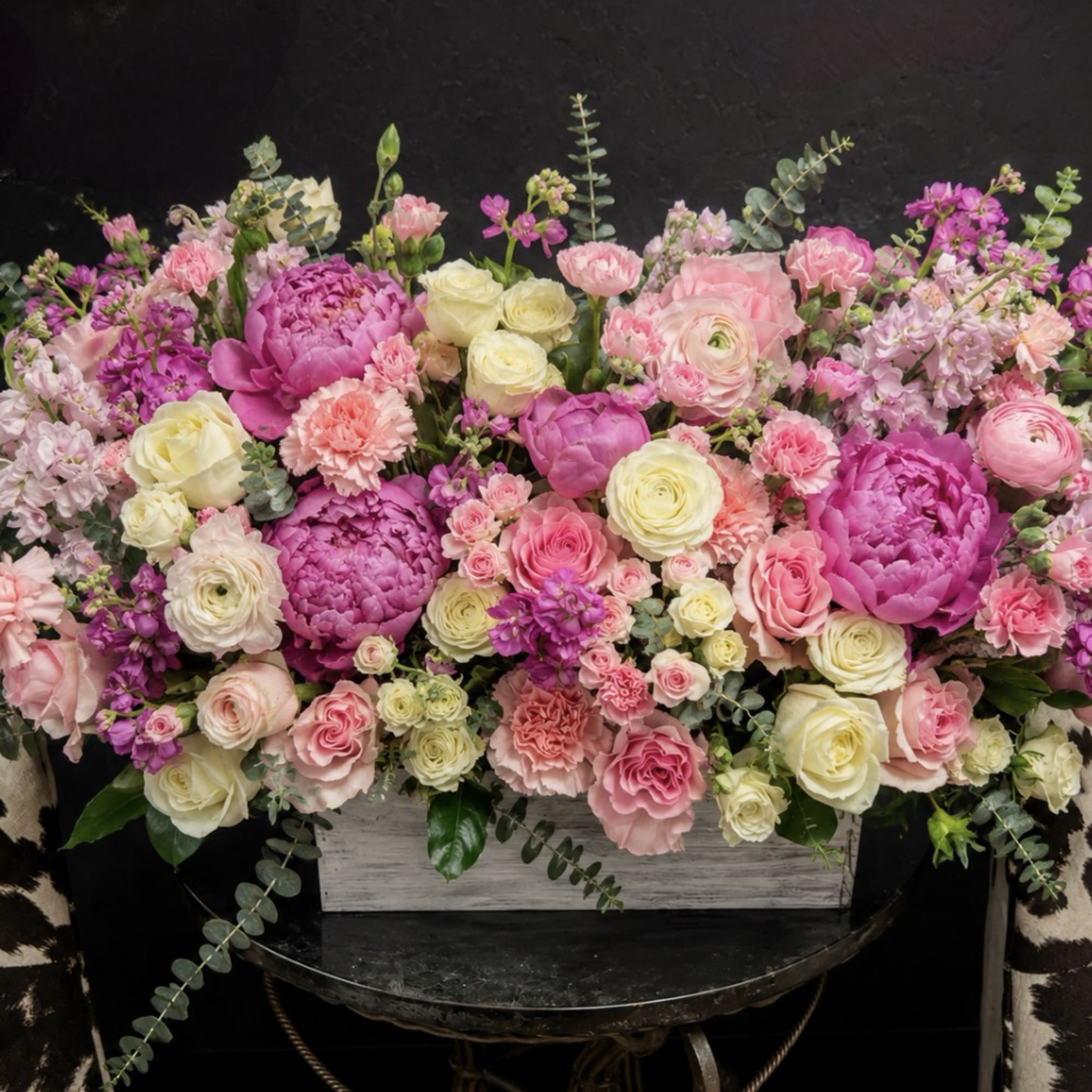 Lush pink peonies and soft ranunculus create a romantic, garden-fresh centerpiece perfect