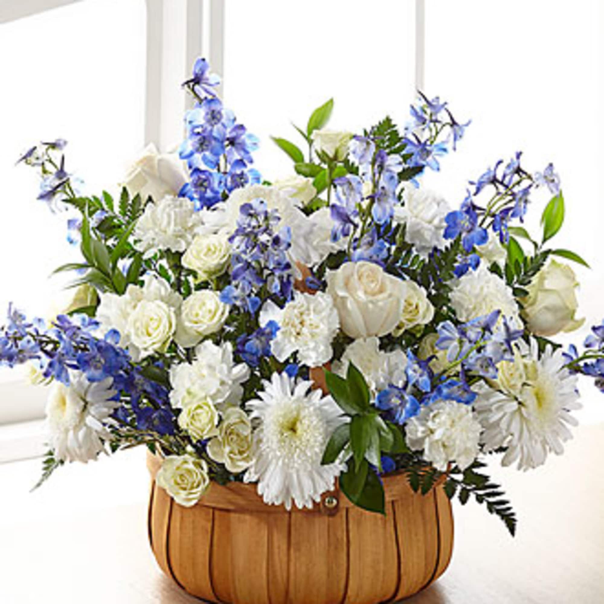 Blue and white flower arrangement in a wooden basket