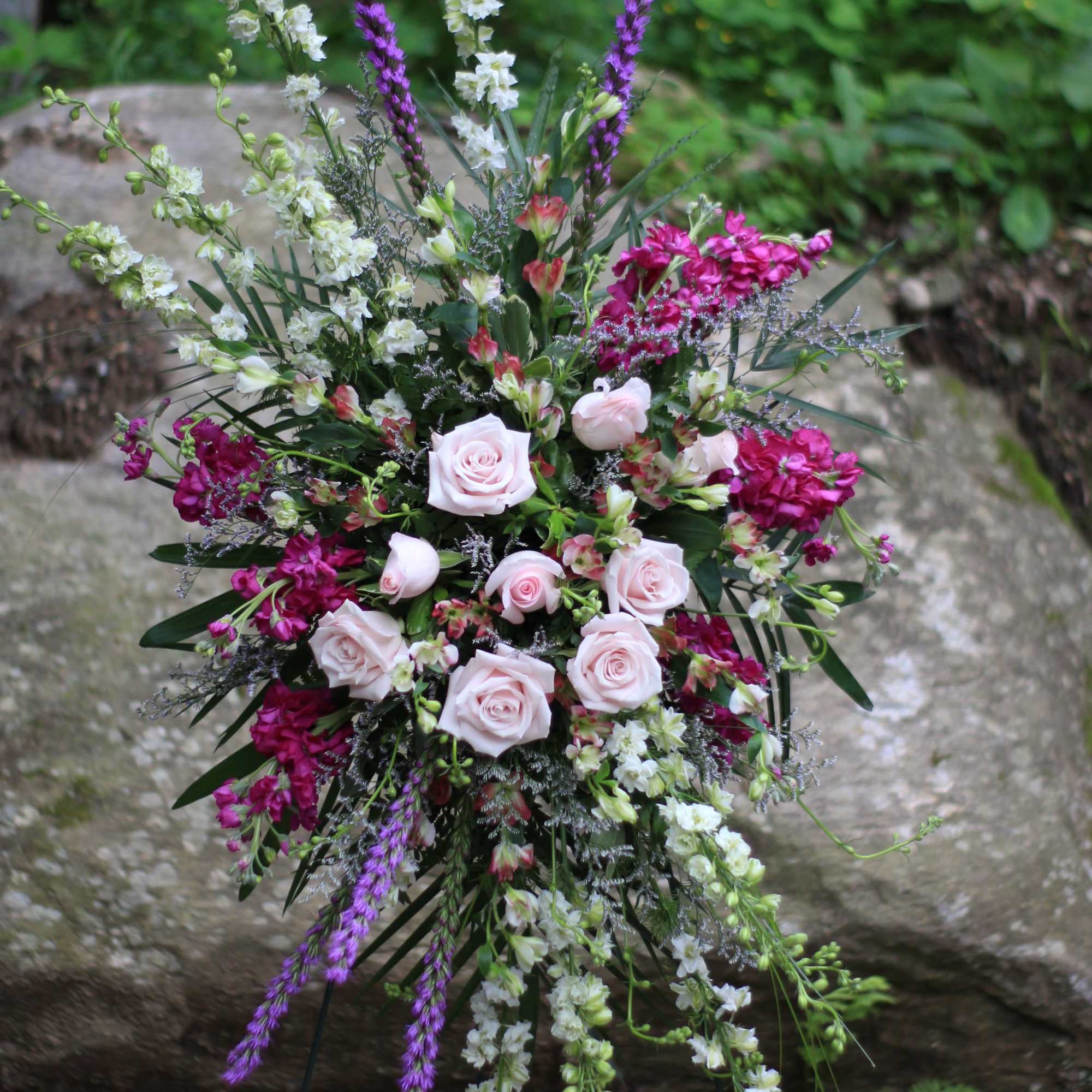 Tall floral spray with pale pink roses and purple and white blooms