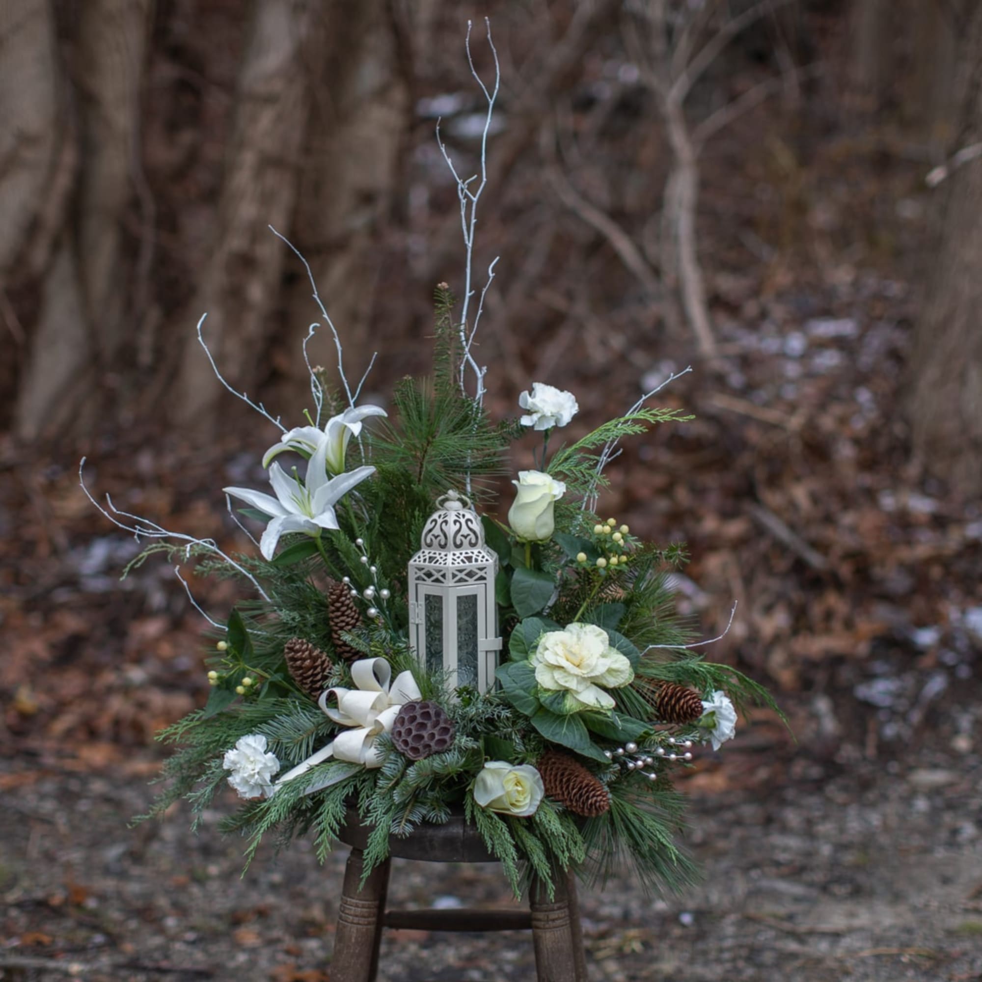 Winter floral arrangement with white lilies and a lantern centerpiece