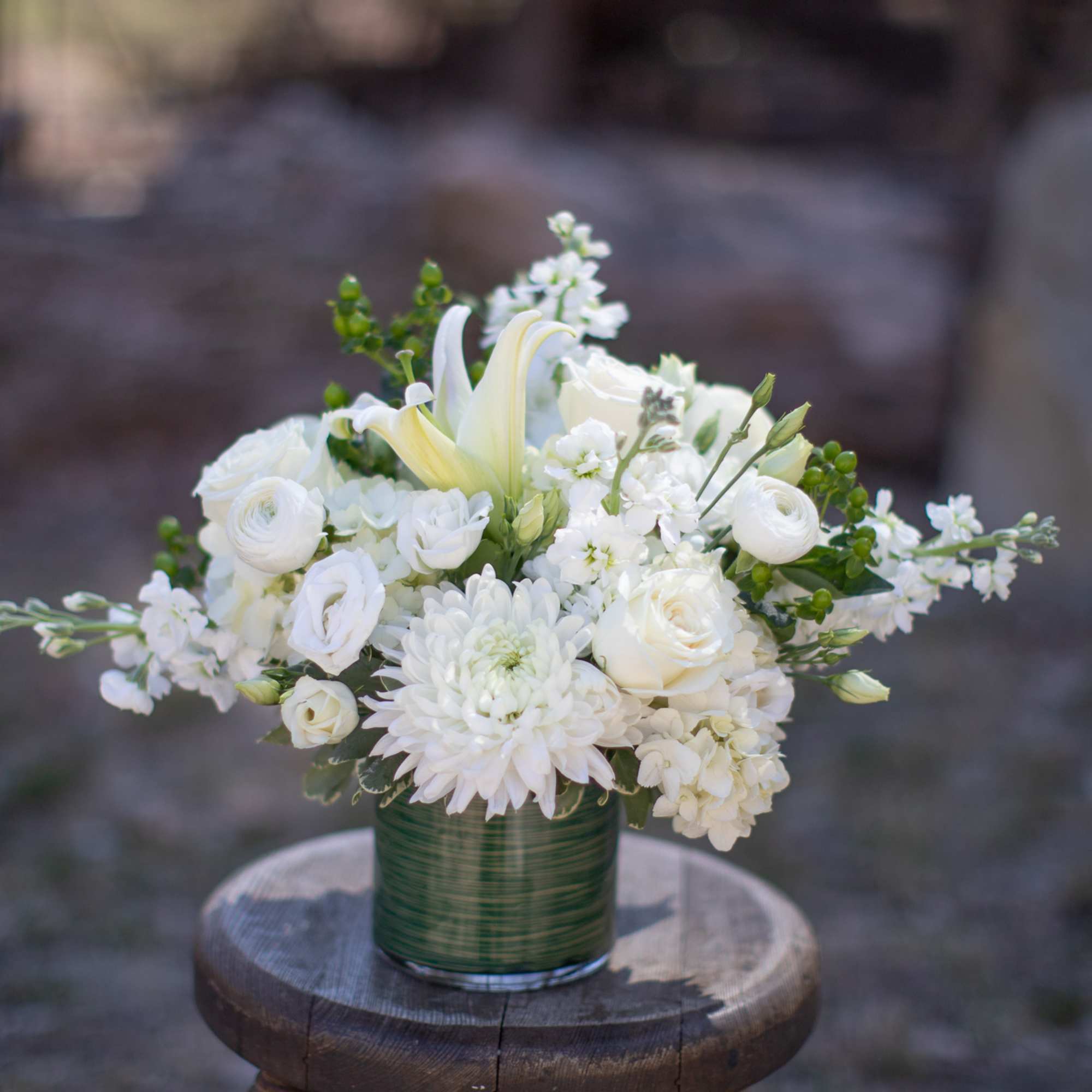 White floral arrangement in a green glass vase