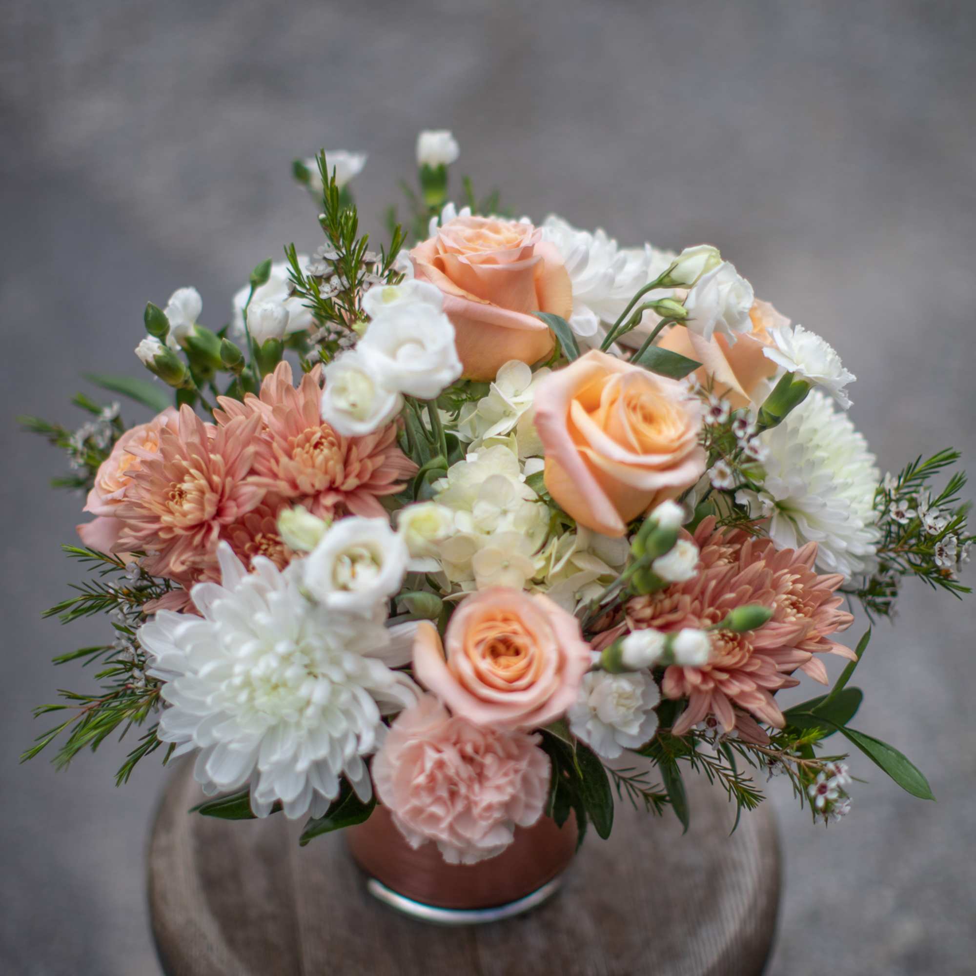 Peach roses and white chrysanthemums in a small vase