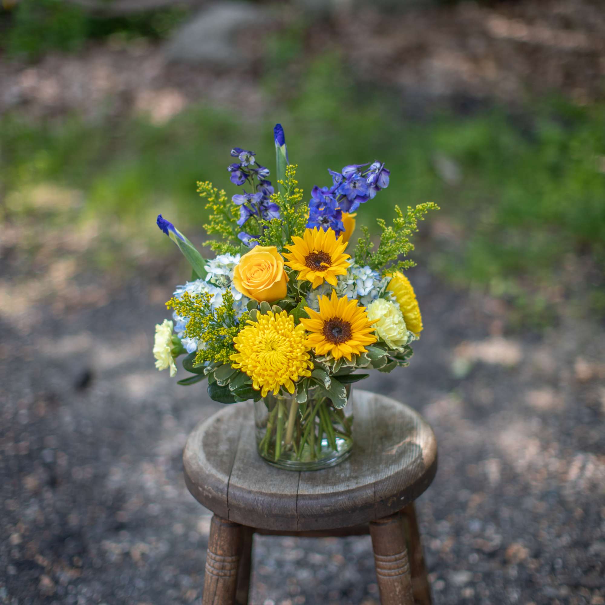 Yellow and blue mixed bouquet in a clear glass vase
