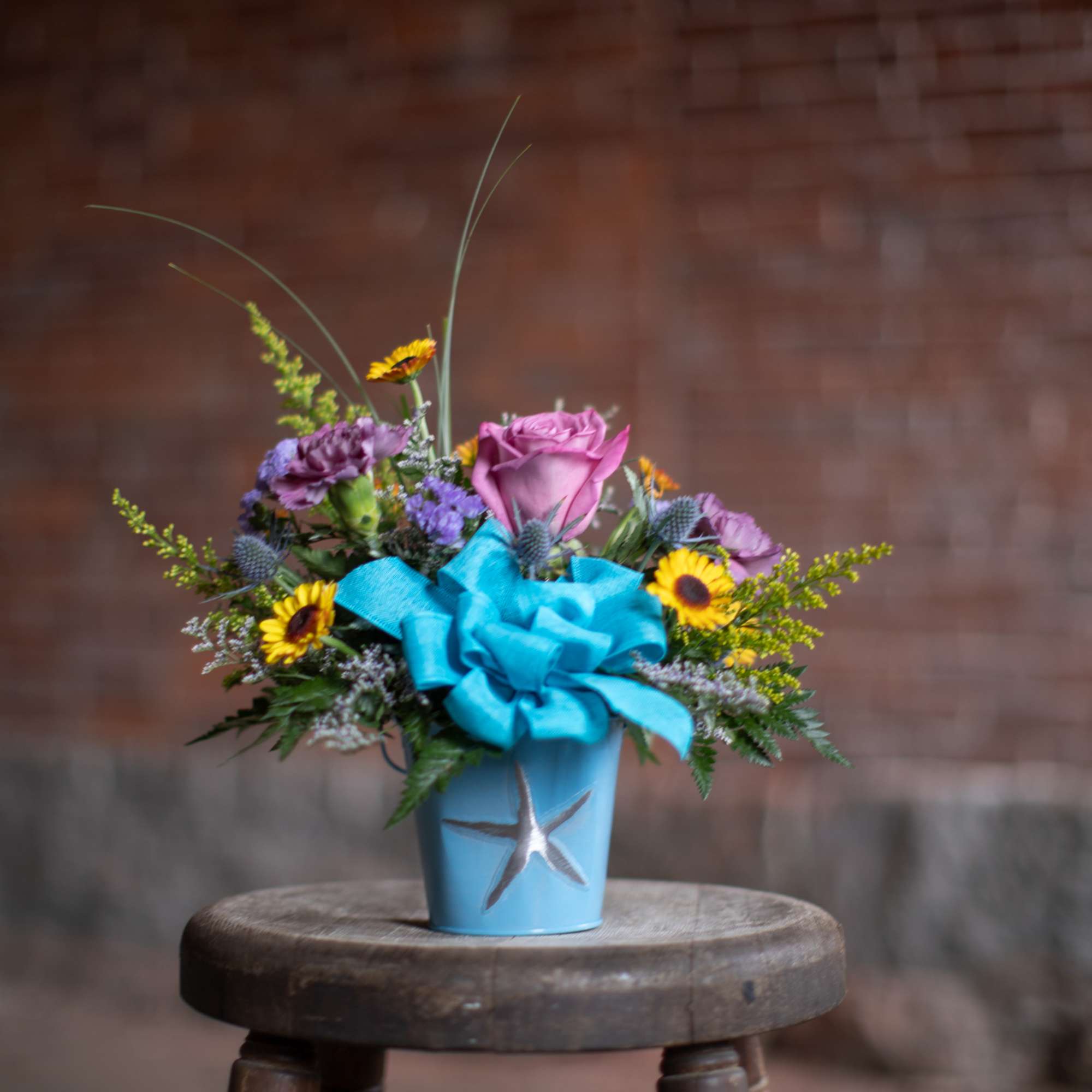 Mixed bouquet in a blue pot with a large blue bow