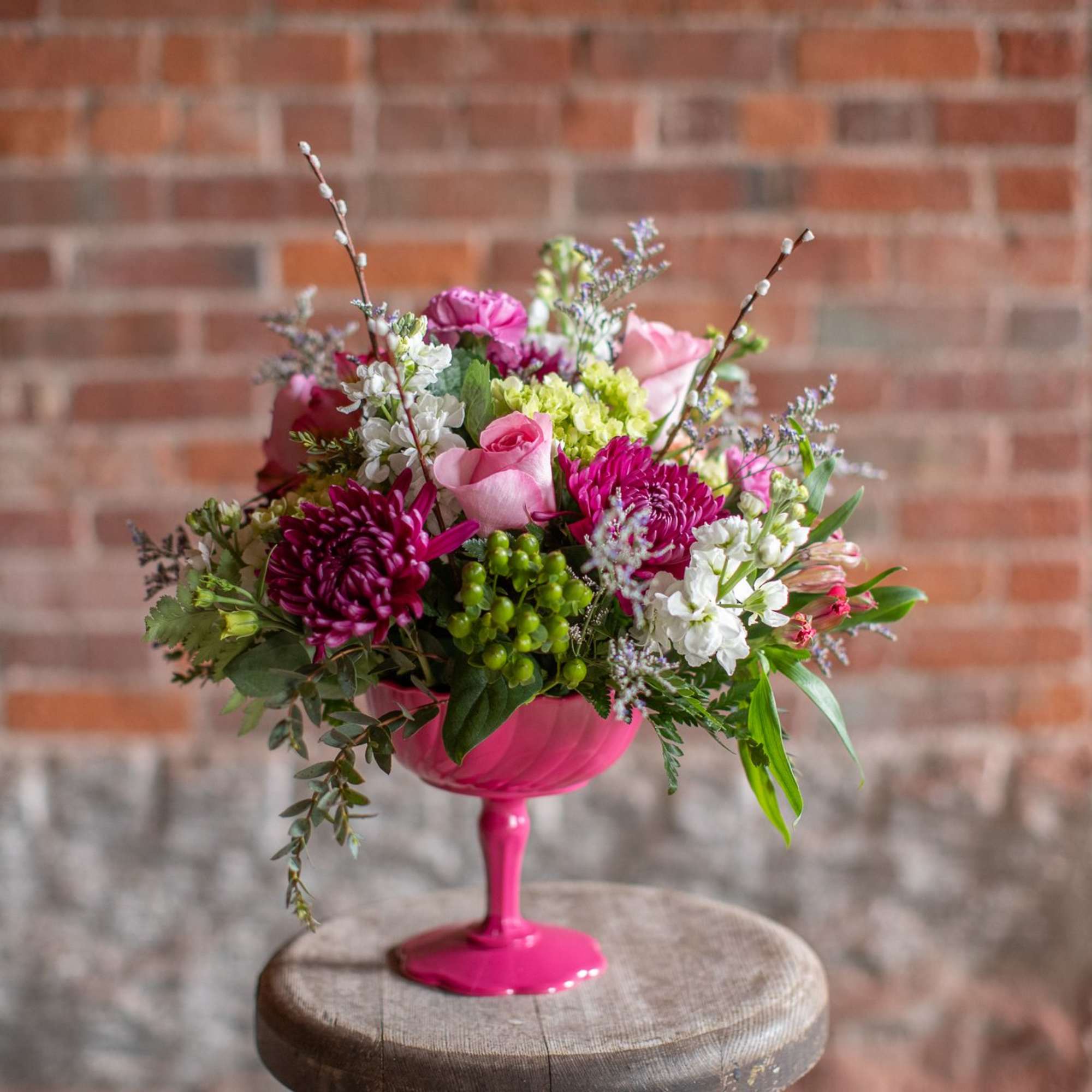 Pink and white mixed bouquet in a bright pink pedestal vase