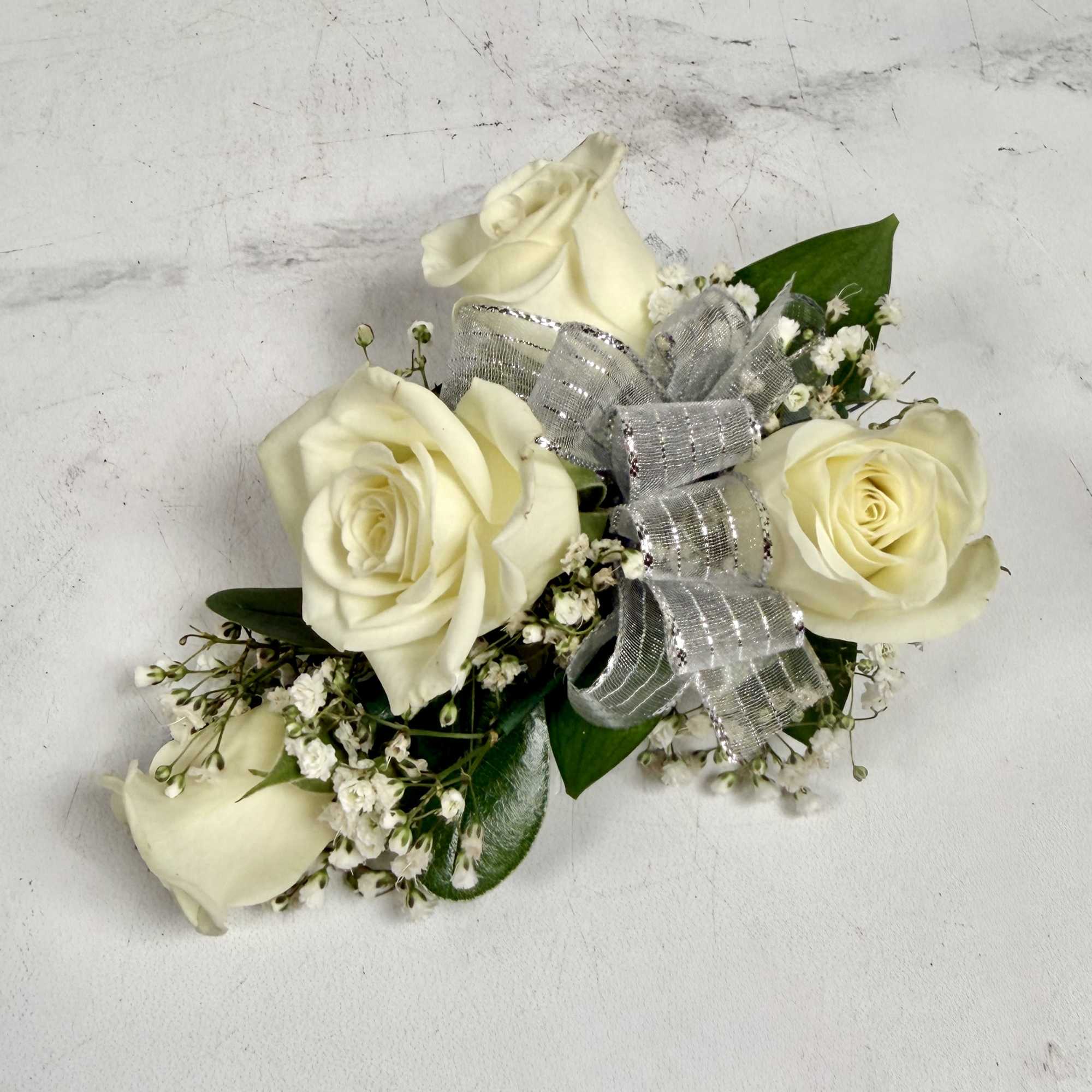 This wrist corsage features three white spray roses, babies breath and white, photo 3 of 3