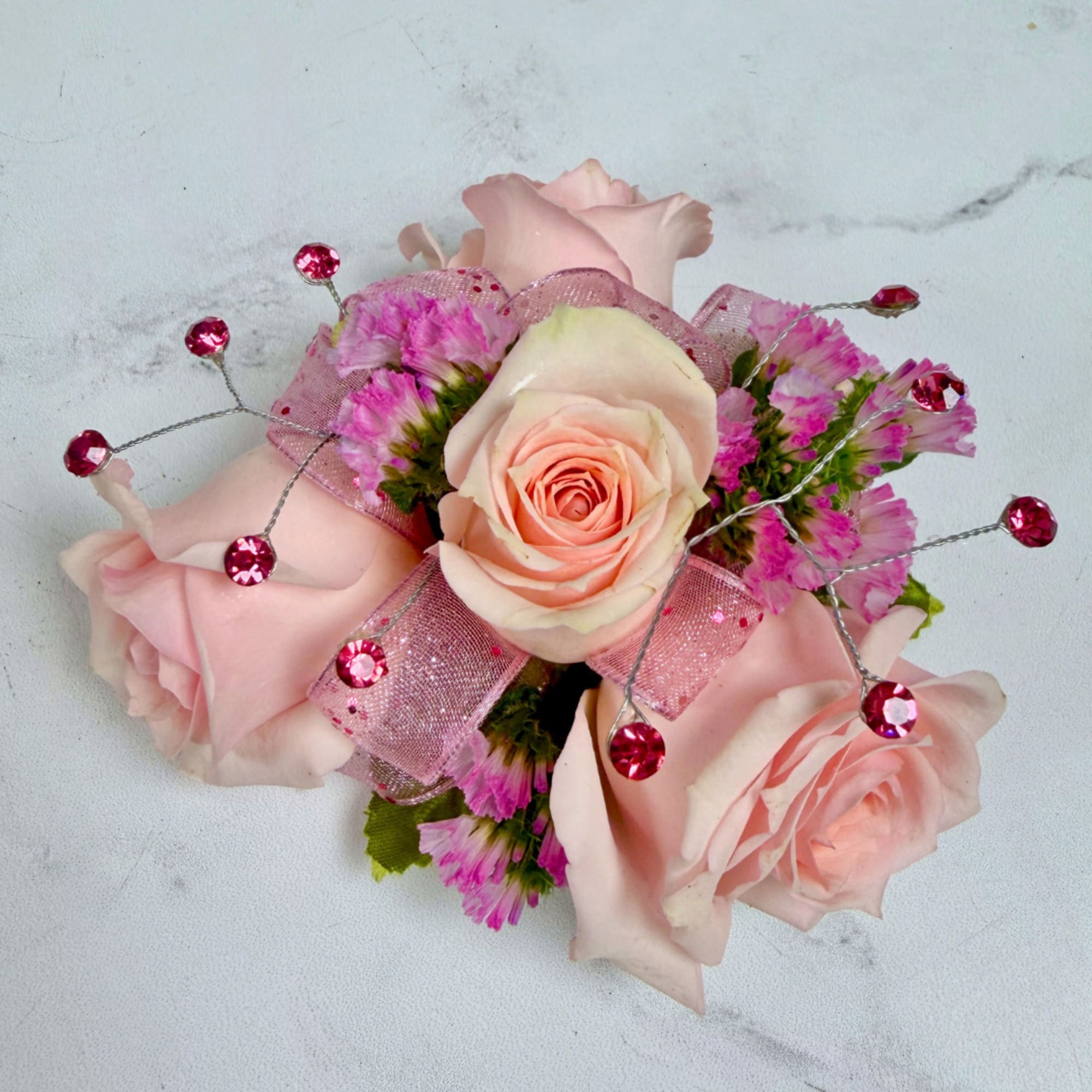 A cluster of petite blush pink spray roses accented with tiny pink