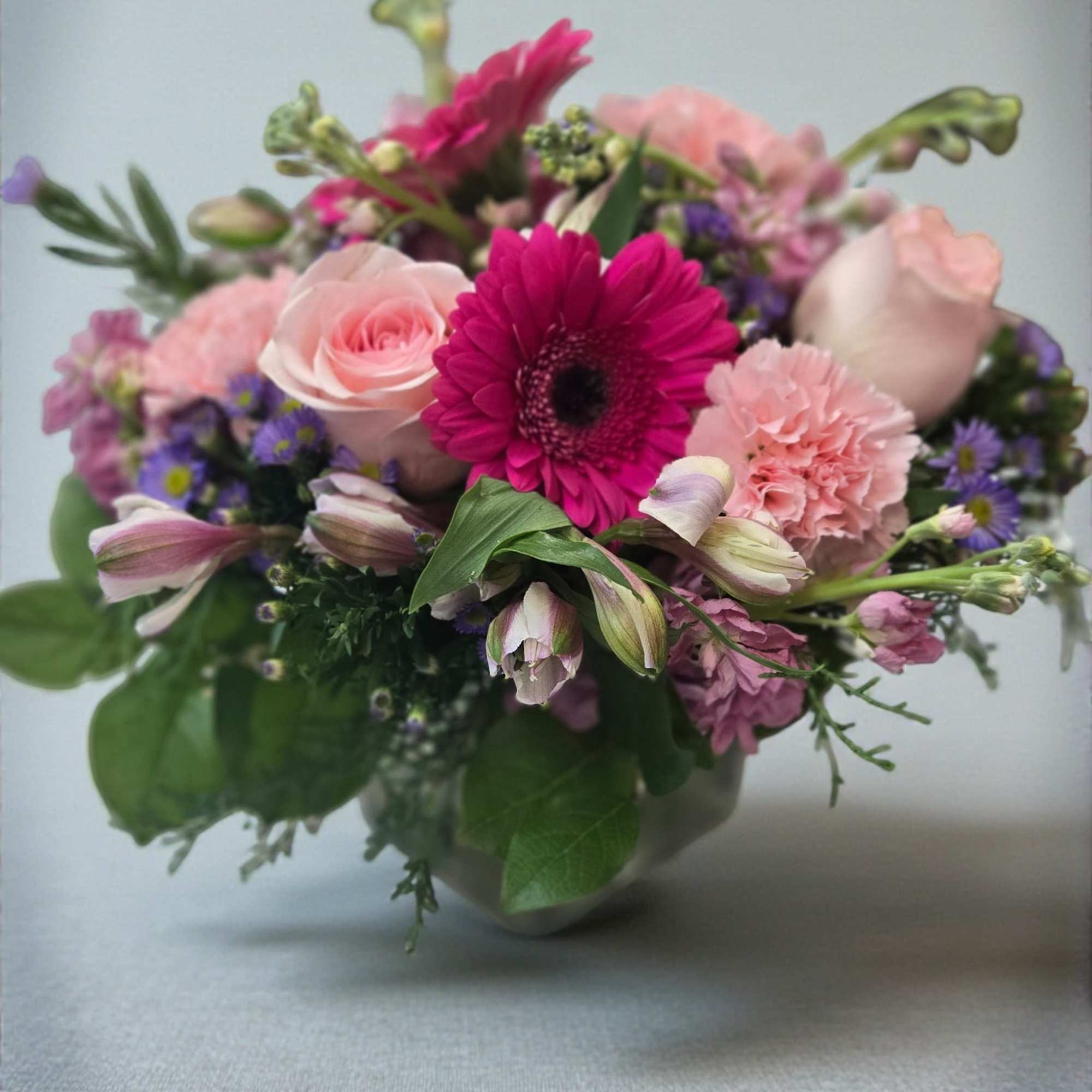 Bright gerbera daisies and blush roses create an immediate "wow" - a