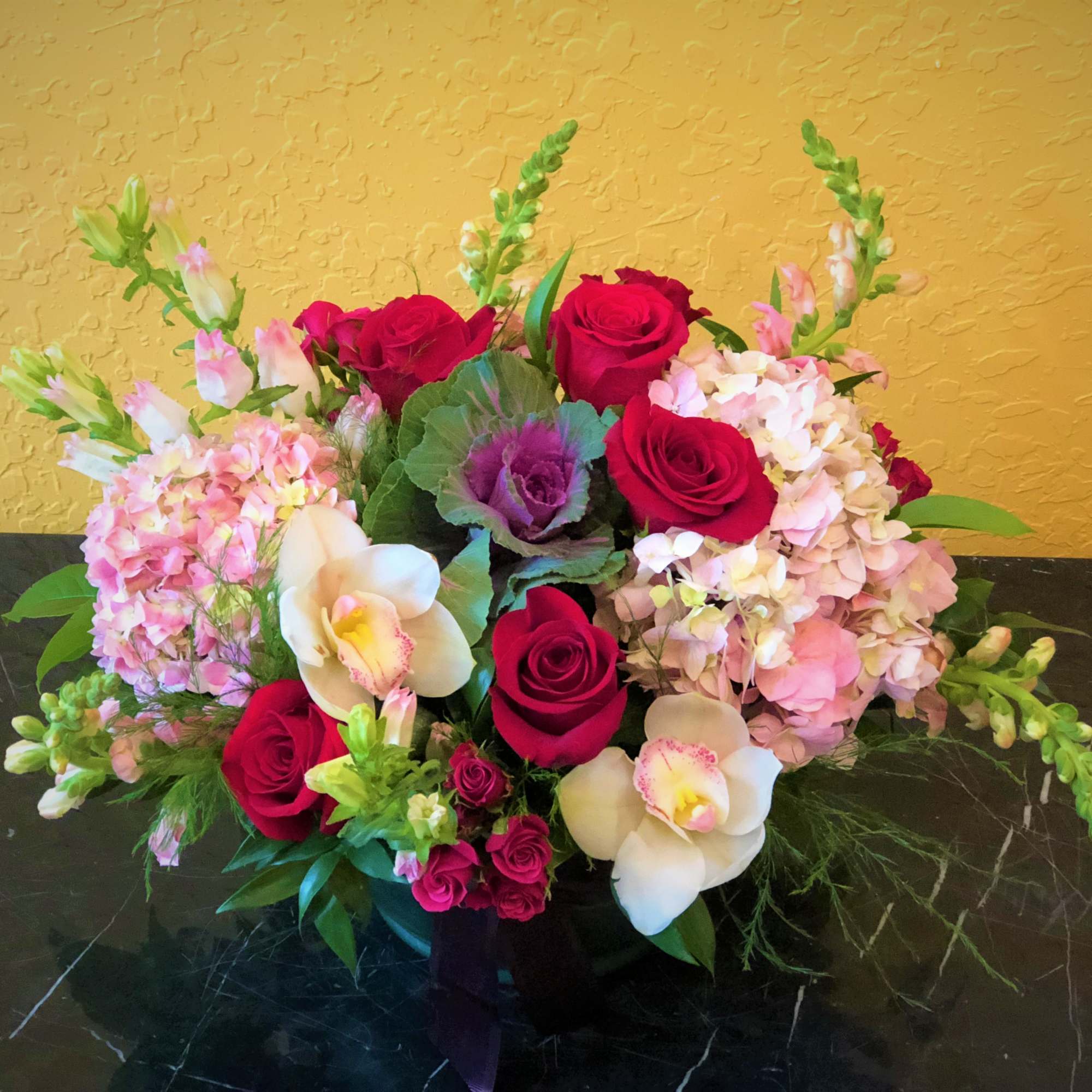 Bouquet of red roses, pink hydrangeas, and white orchids