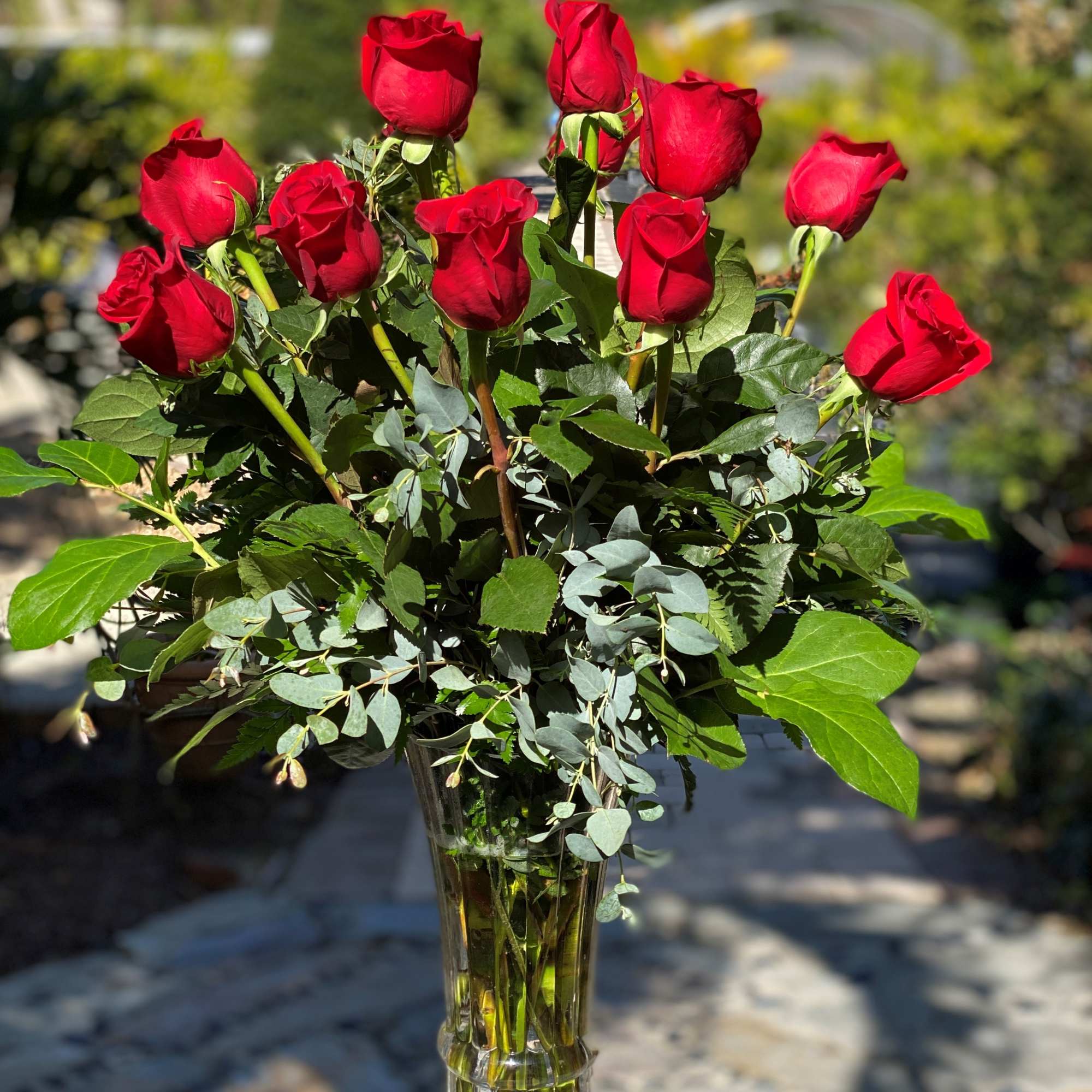 Red roses arranged in a clear glass vase
