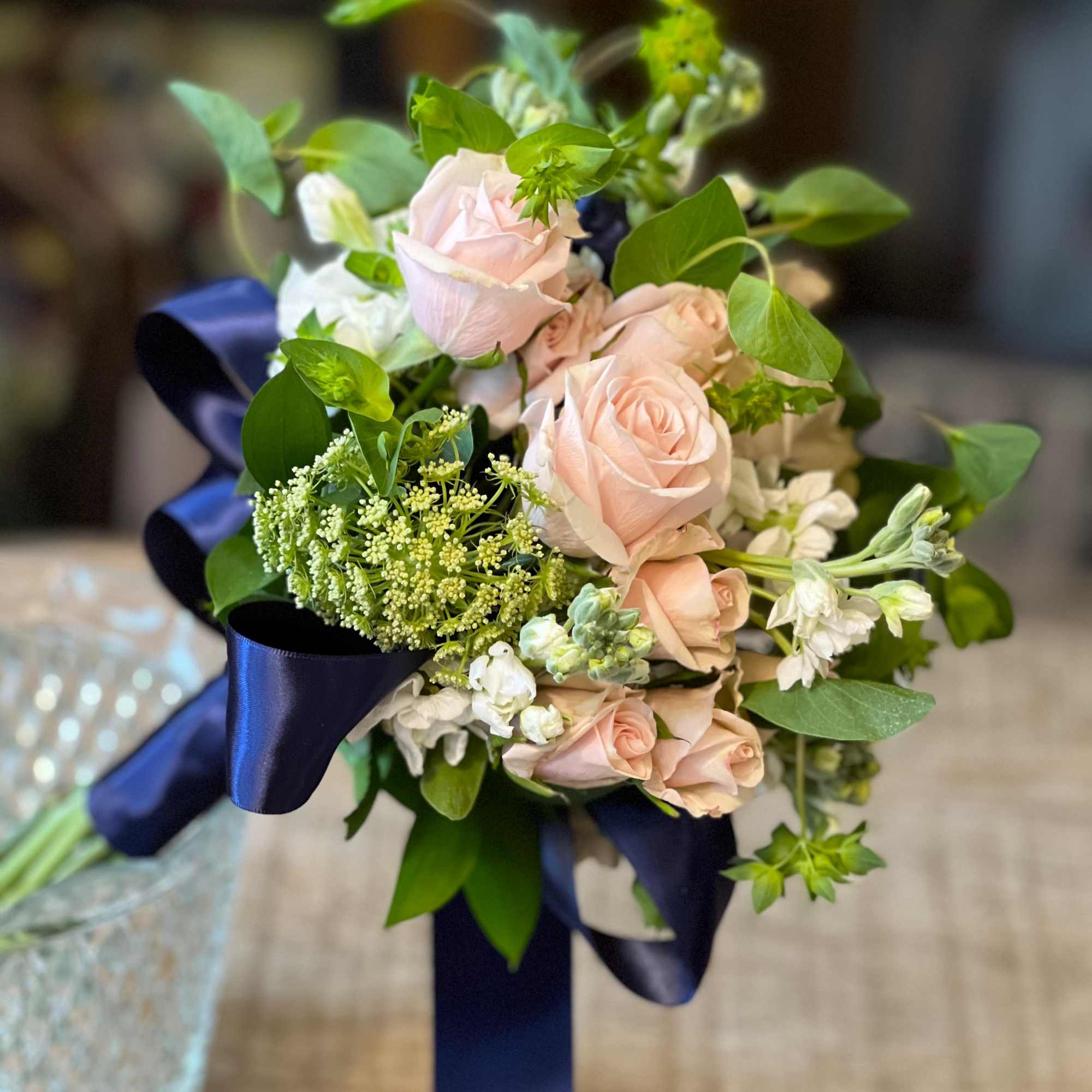 Bouquet of pale pink roses with white flowers and navy ribbon