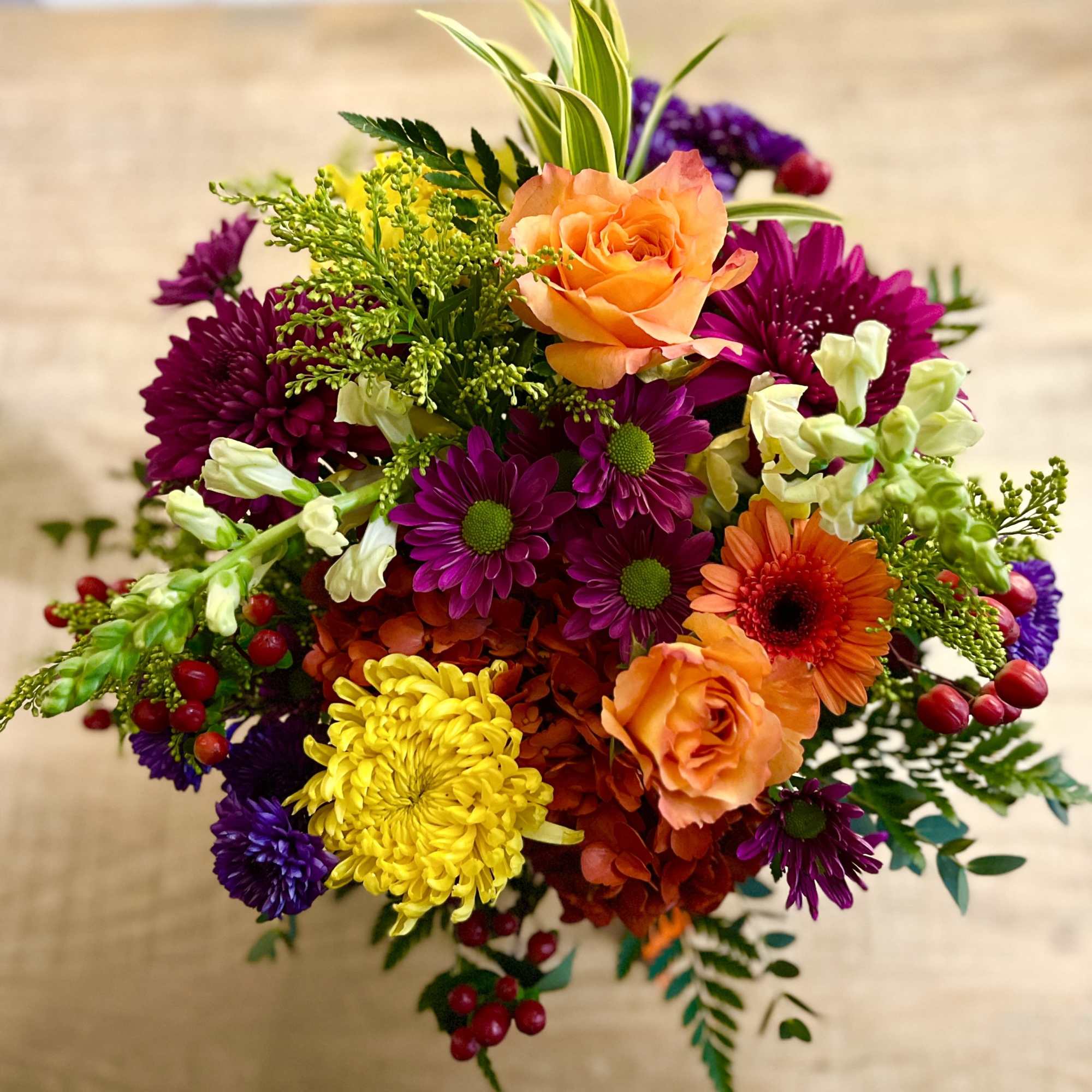 Colorful bouquet with orange roses, purple daisies, and yellow mums