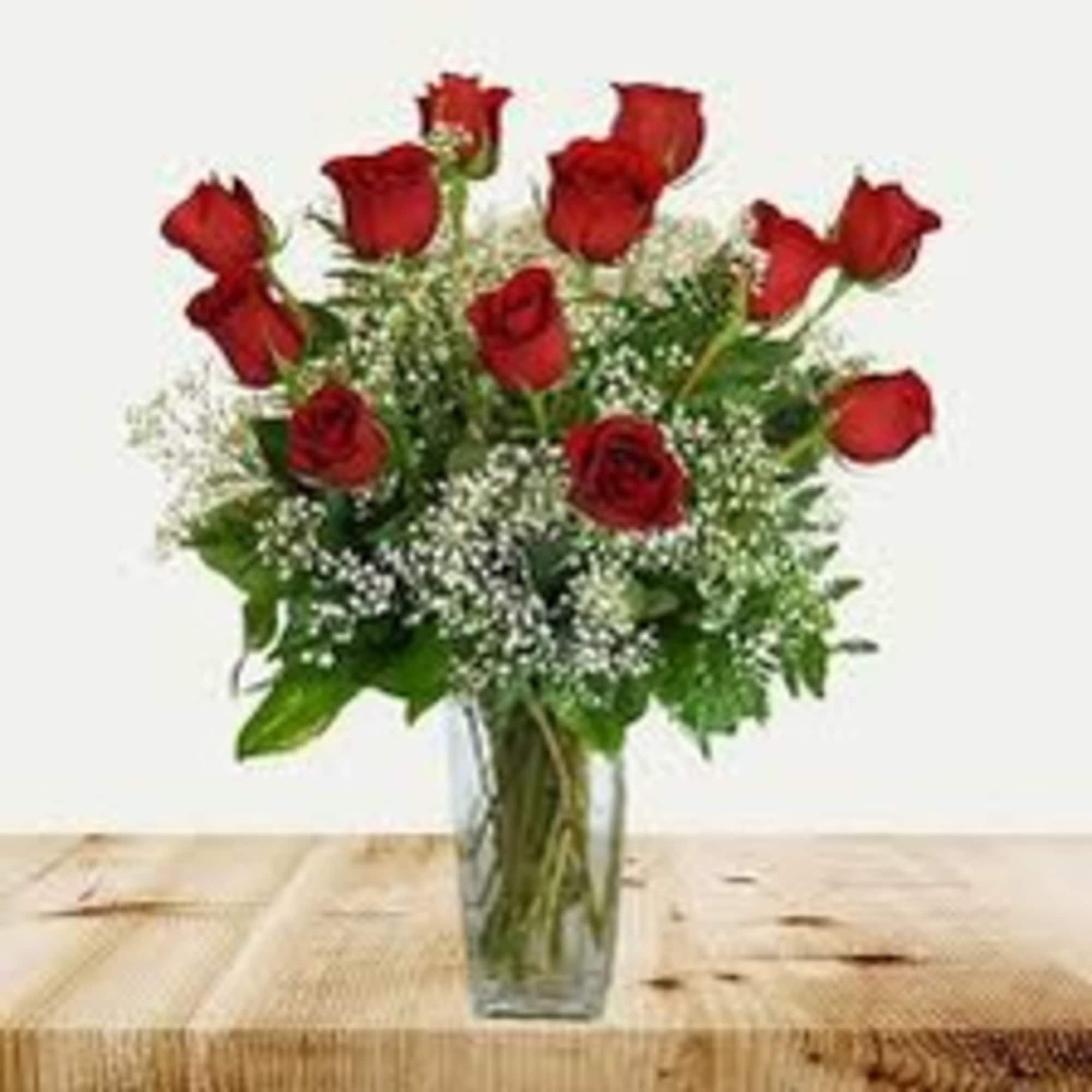 Red roses in a clear glass vase with baby's breath