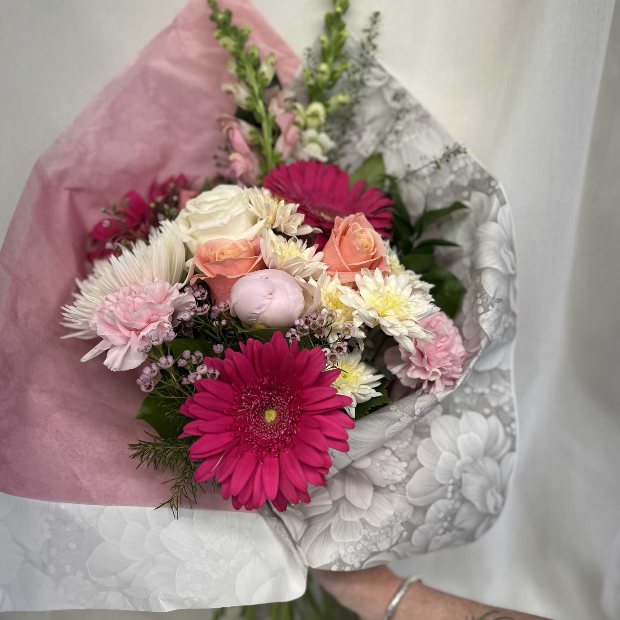 Hand-tied bouquet with pink gerbera daisies, roses, and chrysanthemums