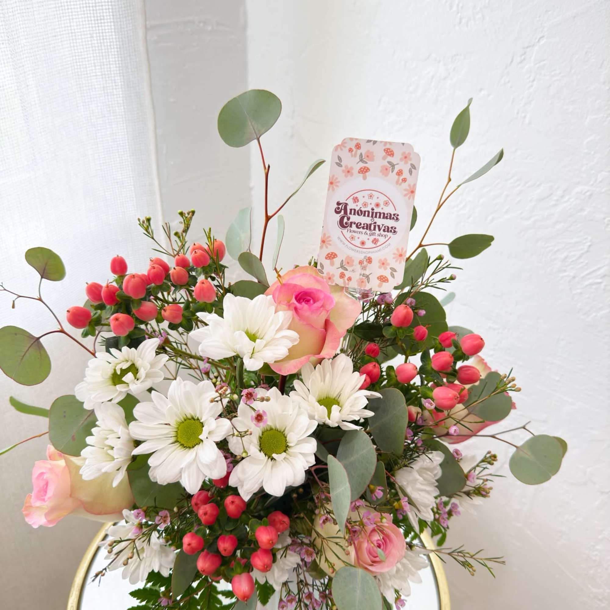 Pink roses and white daisies arranged in a glass vase