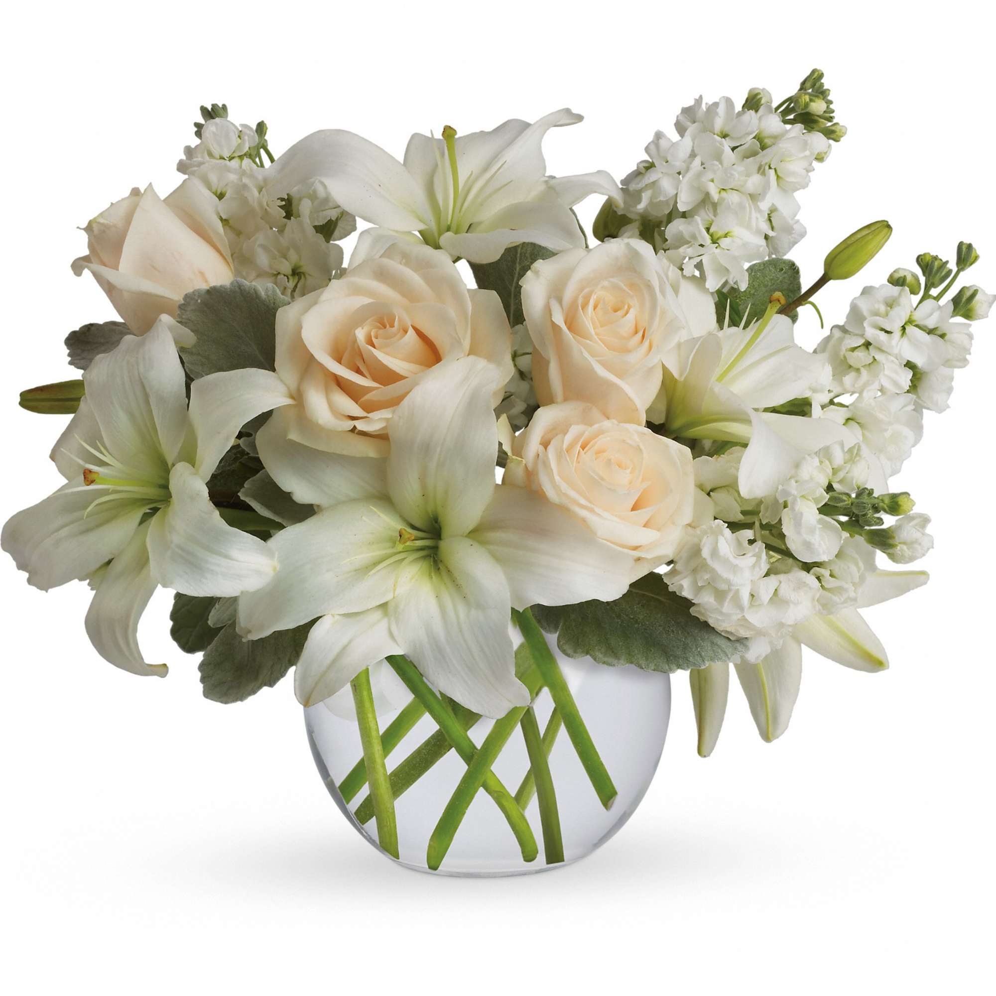 Low arrangement of white lilies and cream roses in a round clear glass vase with crisscrossed stems