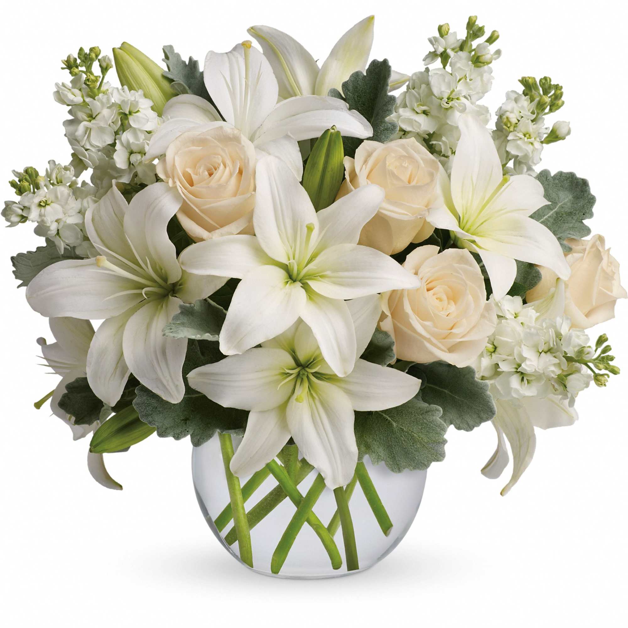 Low glass vase with white lilies, cream roses, and white blooms in a compact arrangement