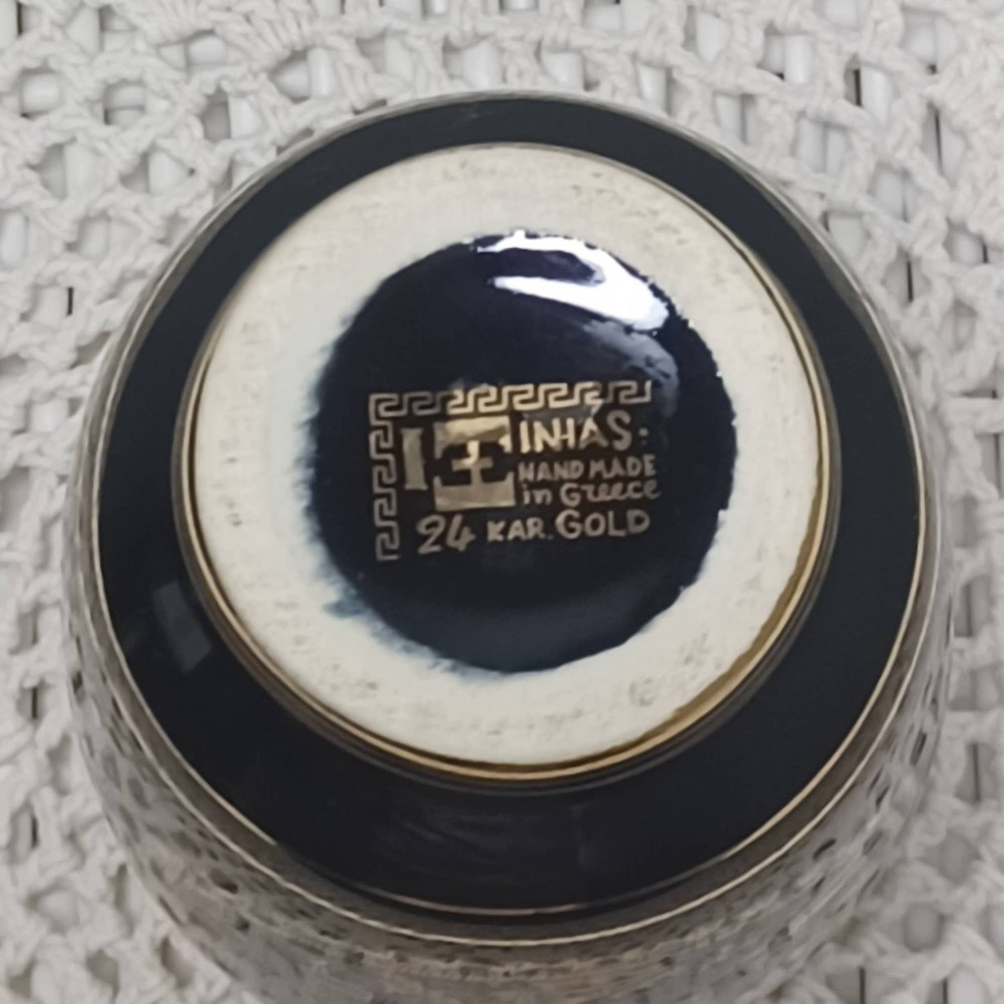 Round black-and-white decorative container with gold lettering