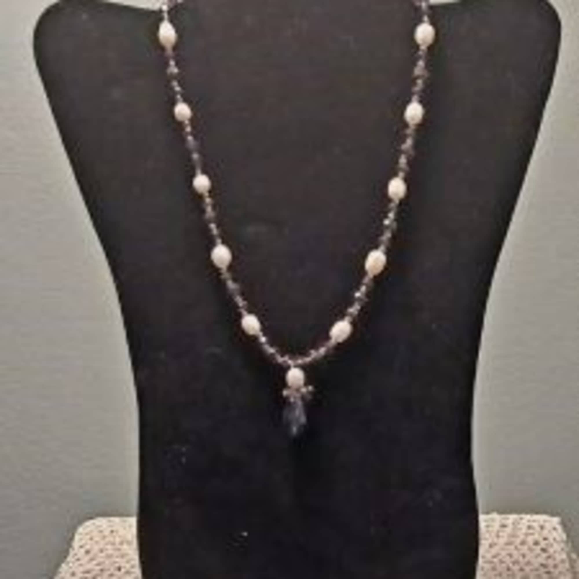 Beaded necklace displayed on a black bust stand
