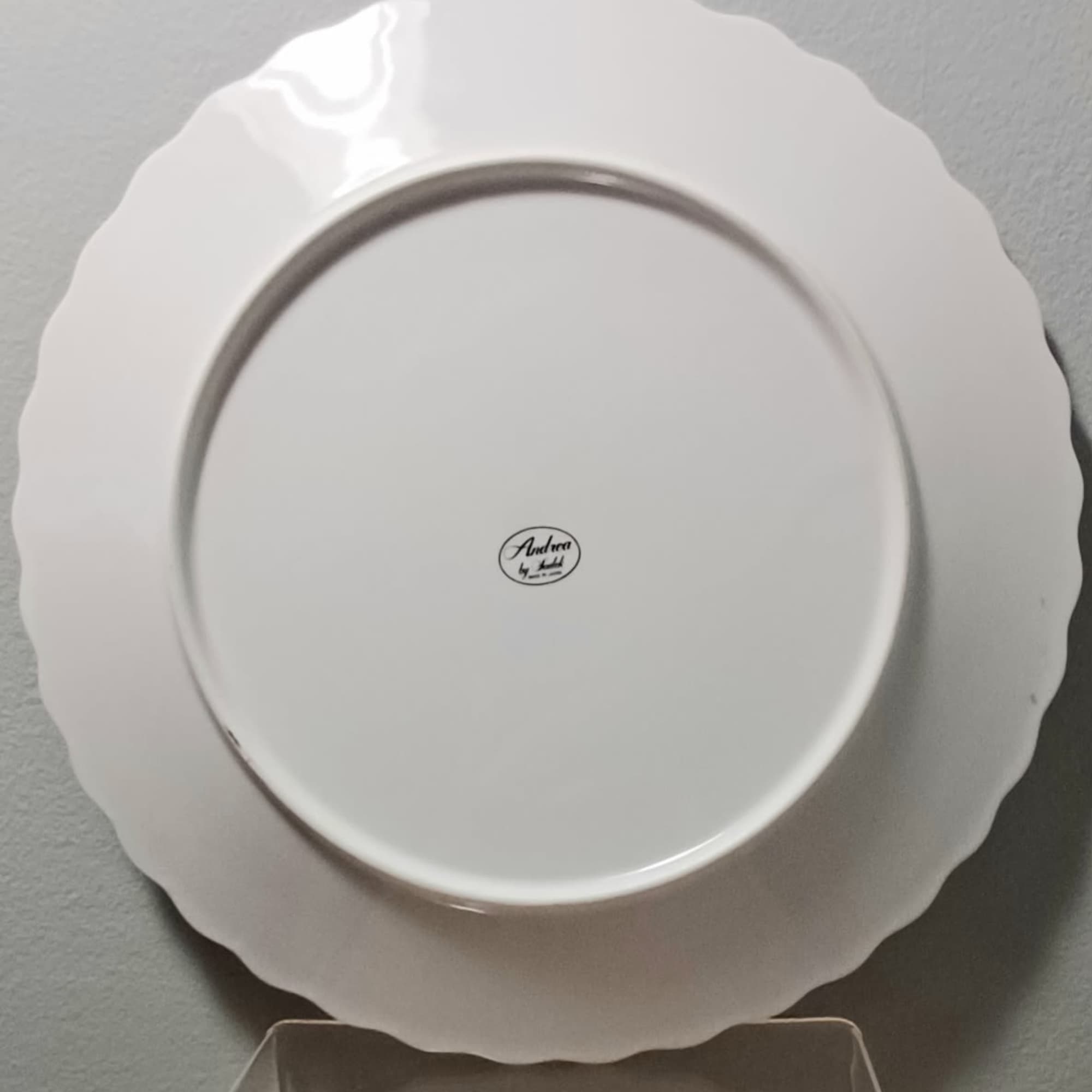 White scalloped ceramic plate shown from the back