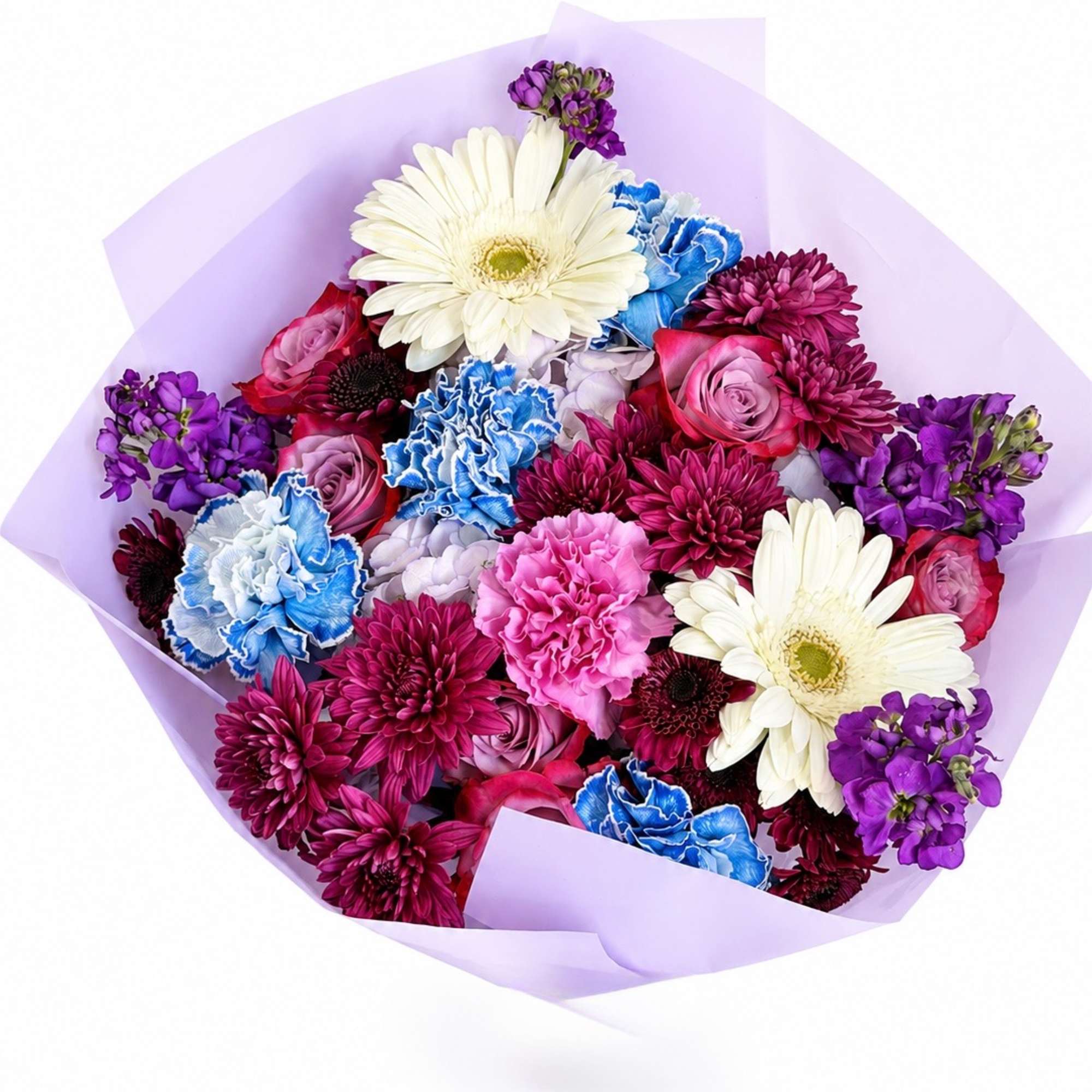 Mixed bouquet of white daisies, carnations, roses, and purple blooms wrapped in lavender paper.