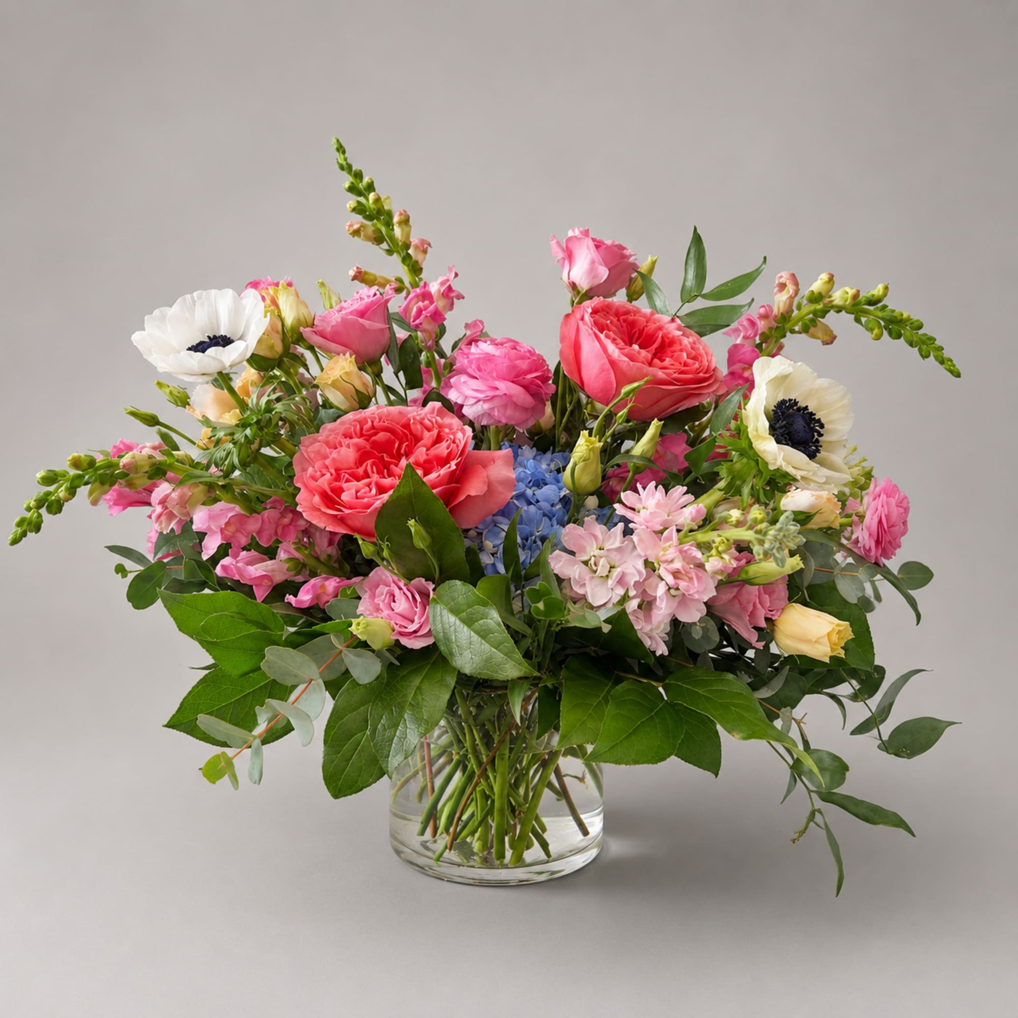 Mixed pink and white flower arrangement in a clear glass vase
