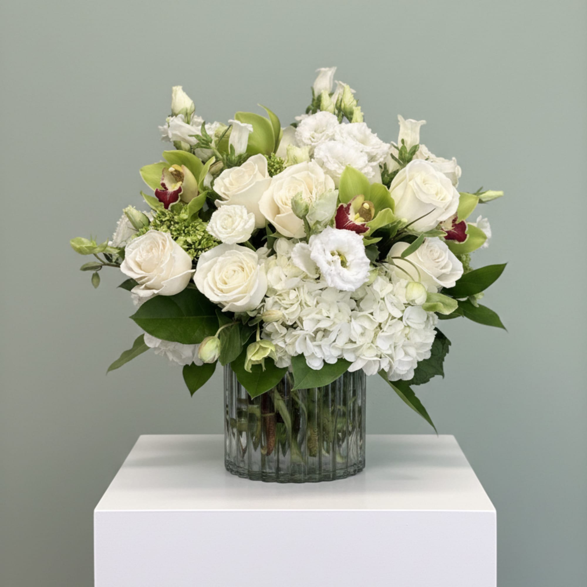 White roses and hydrangeas in a clear glass vase