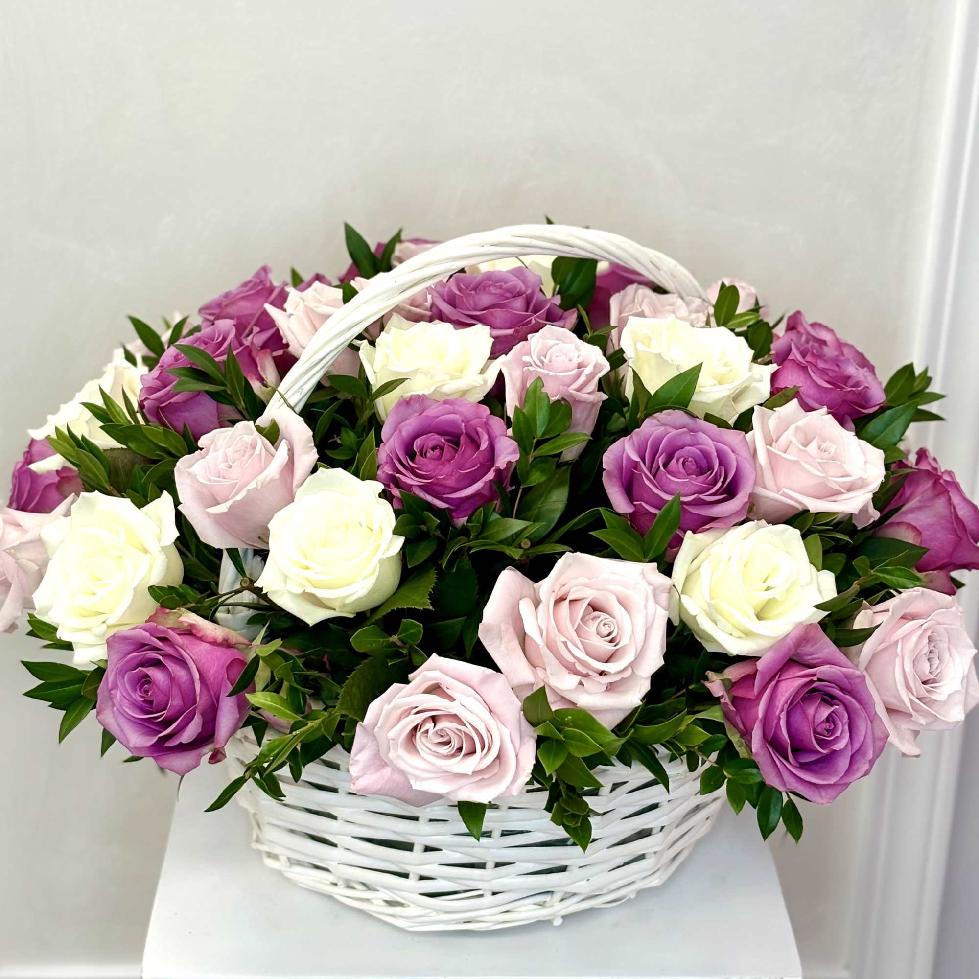 Basket of pink, purple, and white roses