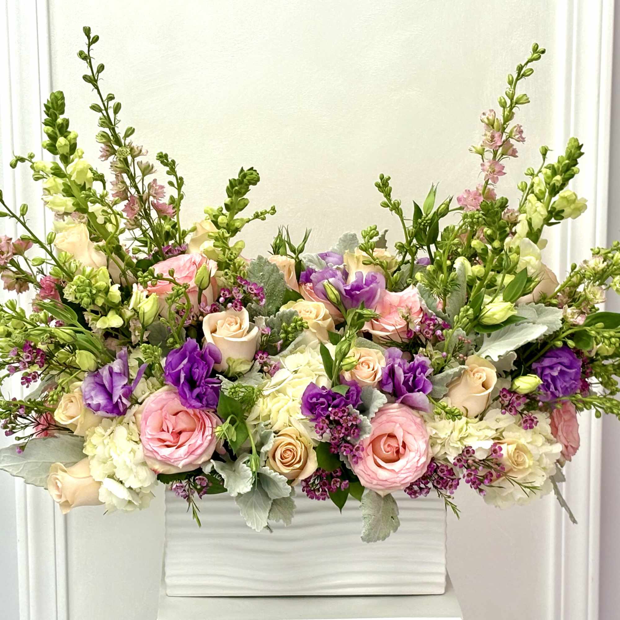 Pastel floral arrangement in a white rectangular vase