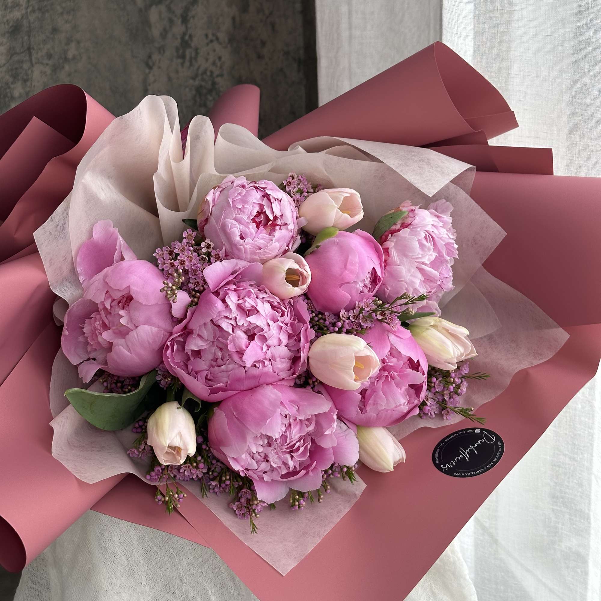 This elegant bouquet features a stunning combination of soft pink peonies and