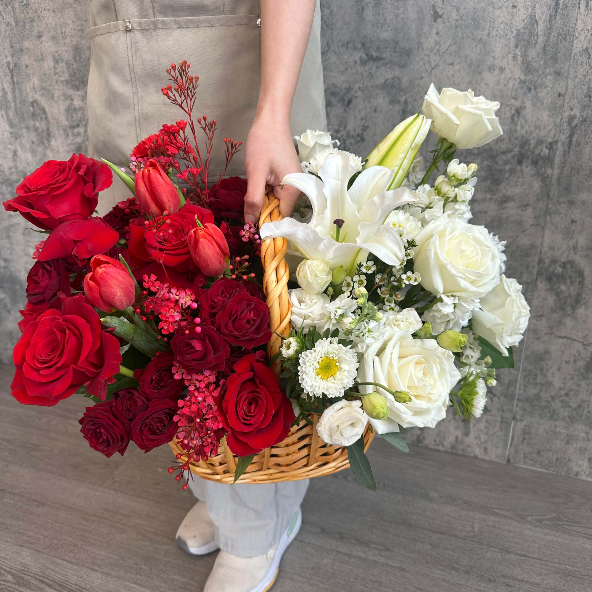 Basket arrangement of red and white roses with lilies