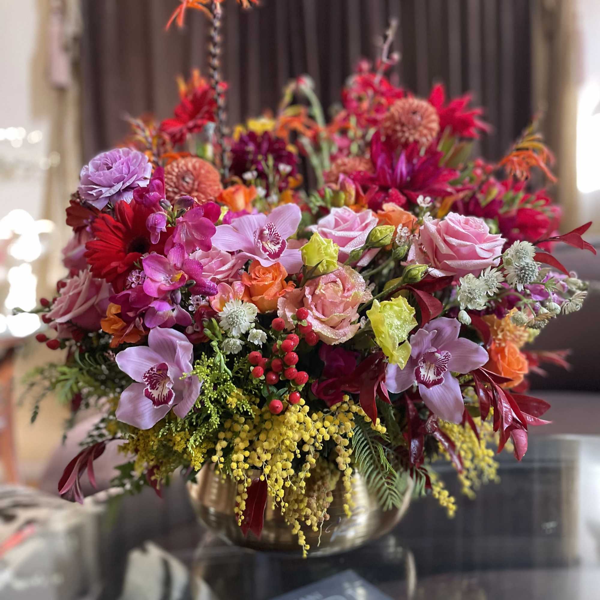 Colorful mixed flower arrangement in a gold vase