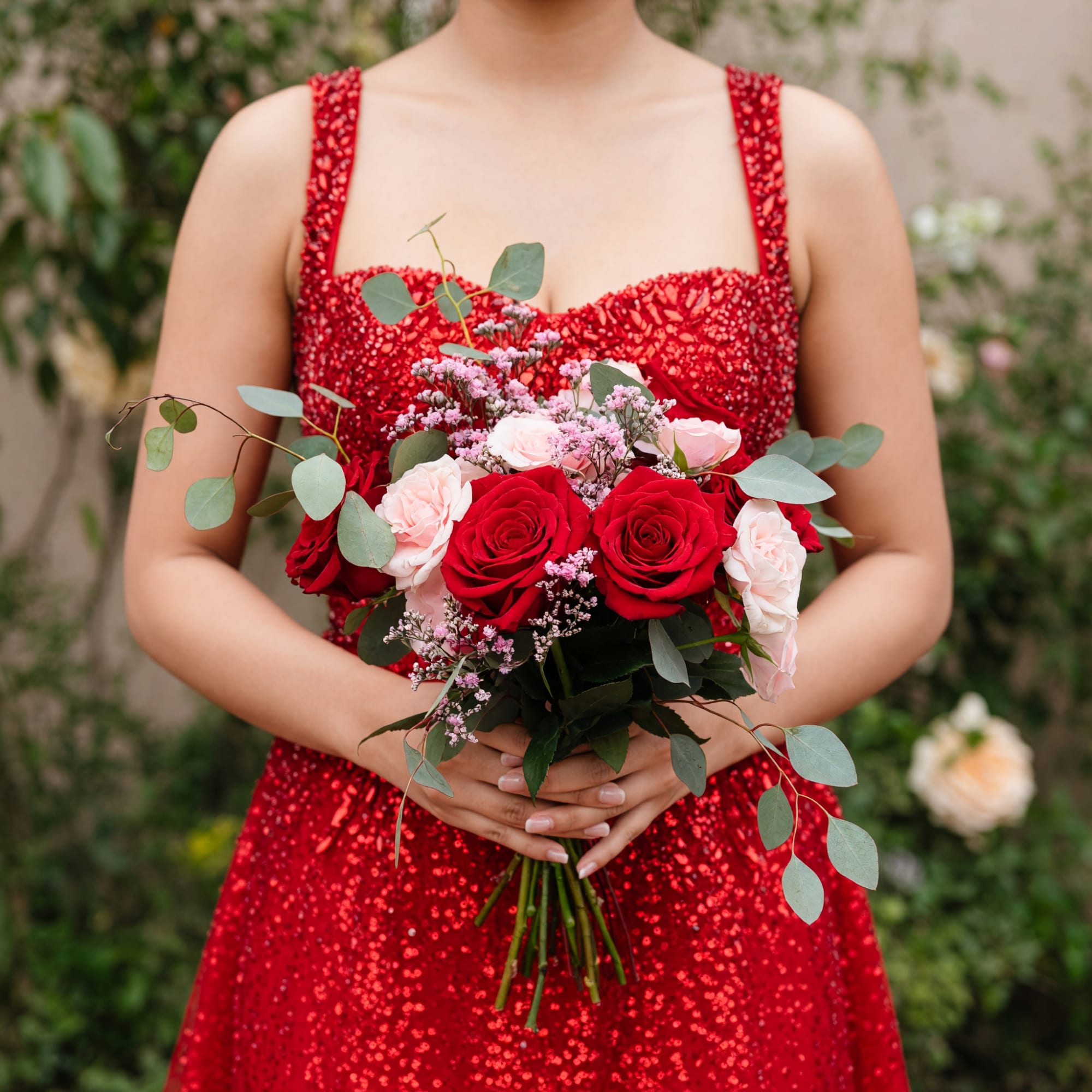 Woman holding a bouquet of red and pale pink roses