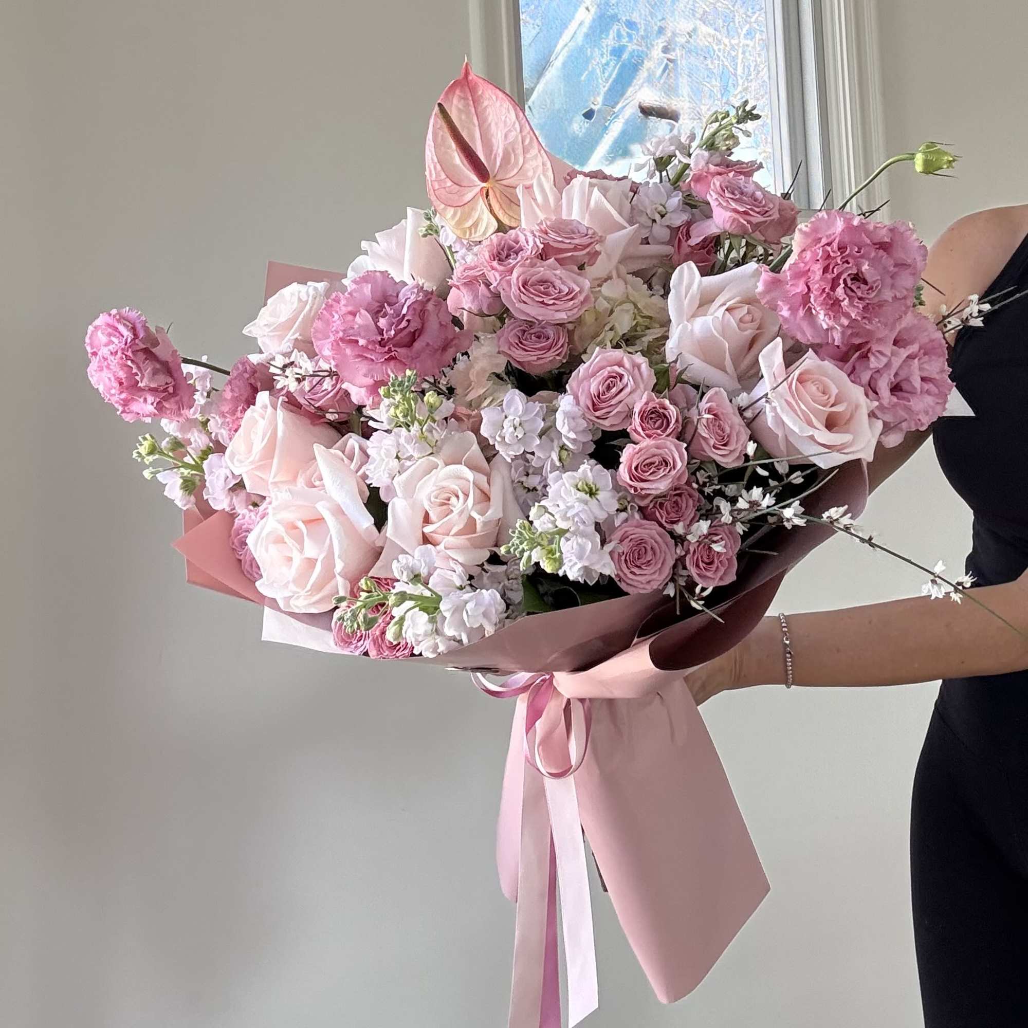 Large pink bouquet with roses, carnations, and white filler flowers
