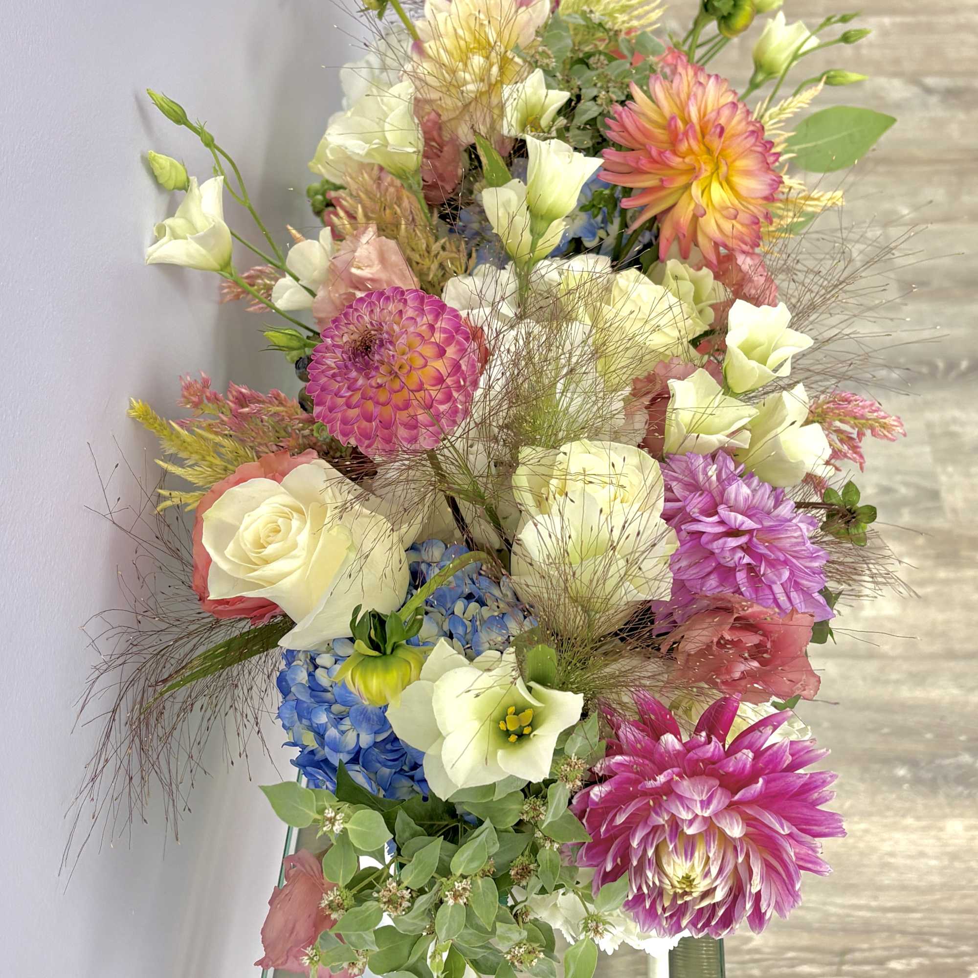 Mixed bouquet with pink, white, and blue flowers in a tall arrangement